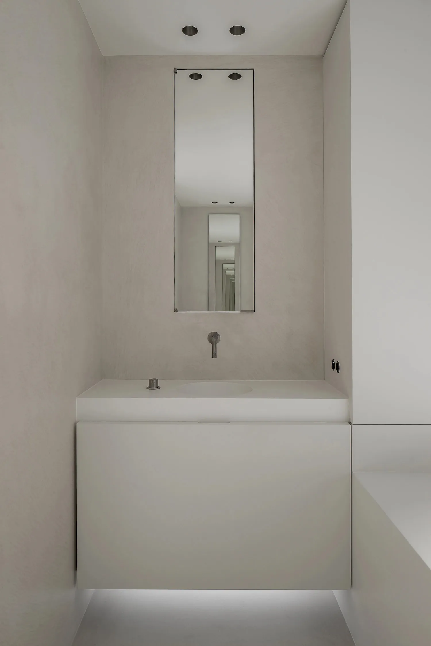 Modern minimalist bathroom with concrete walls and a stainless steel sink.