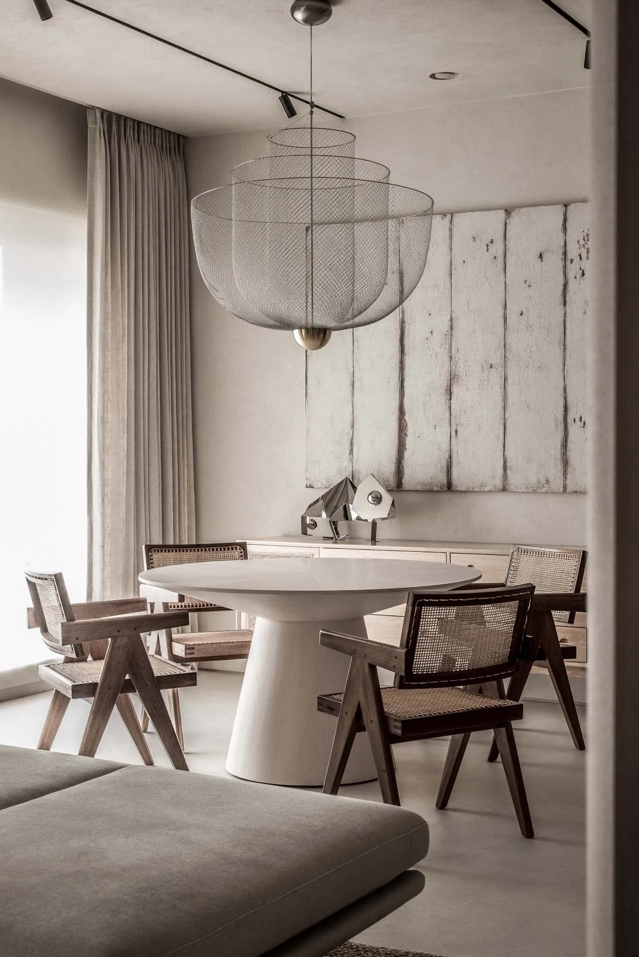 Modern minimalist dining room featuring a metal mesh pendant light fixture.