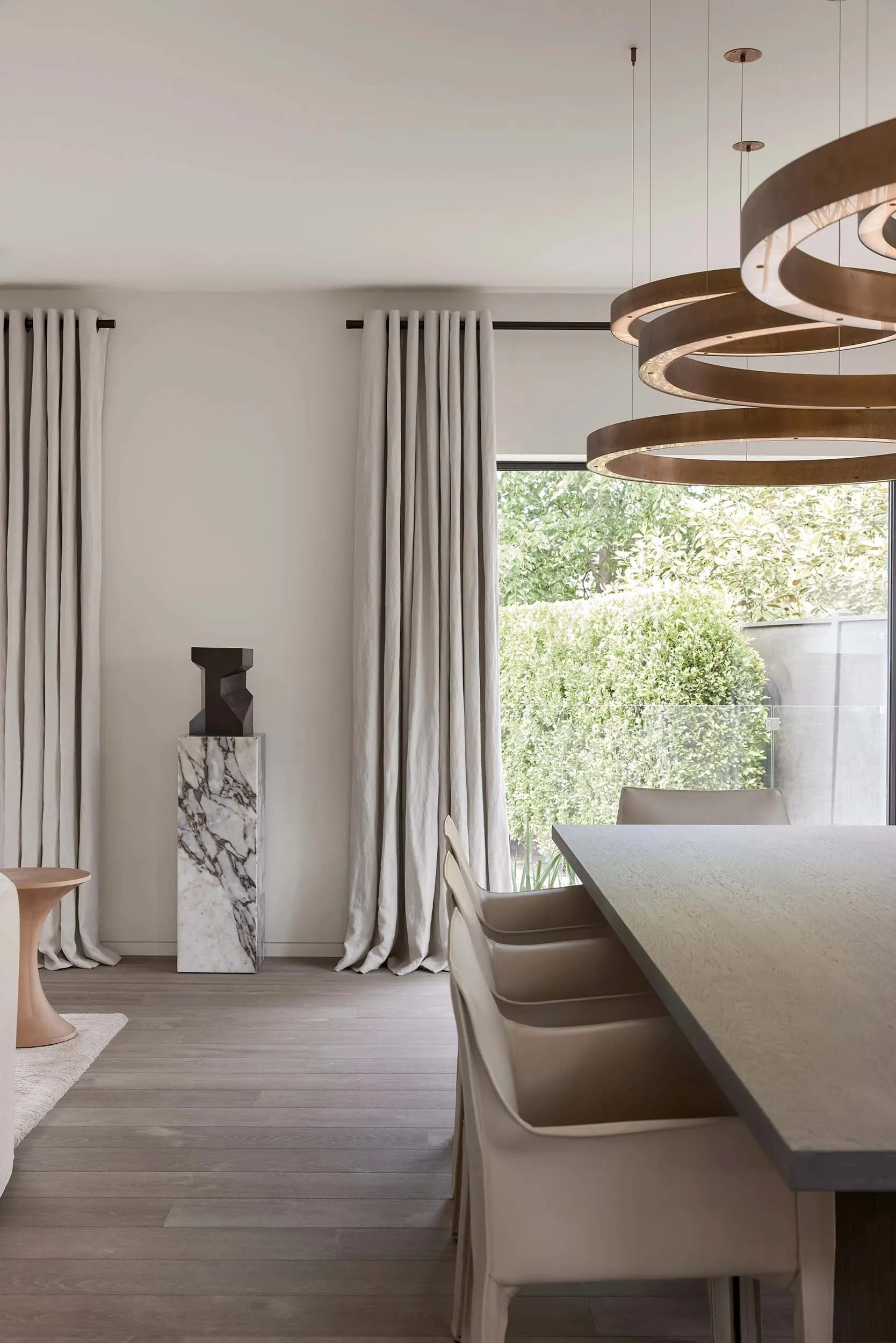 Modern, minimalist residential interior featuring clean lines, neutral tones, and a large window.