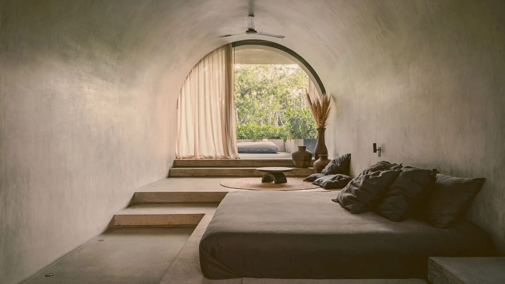 Modern concrete bedroom with a minimalist design and natural light.