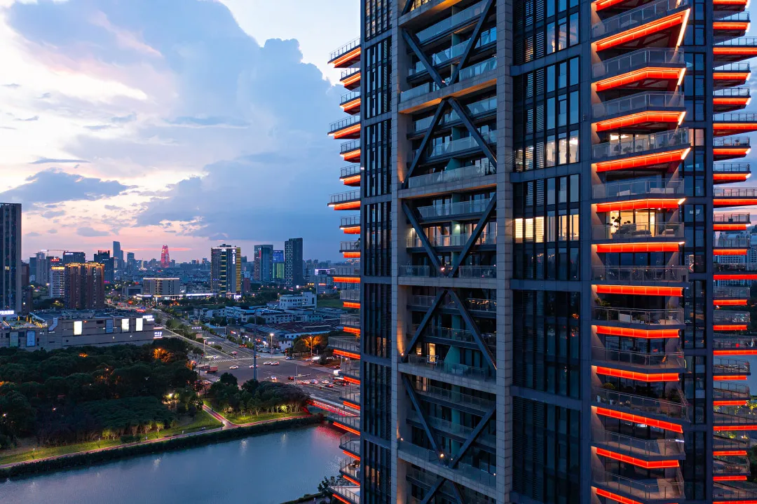 Modern cityscape featuring a glass skyscraper during dusk.
