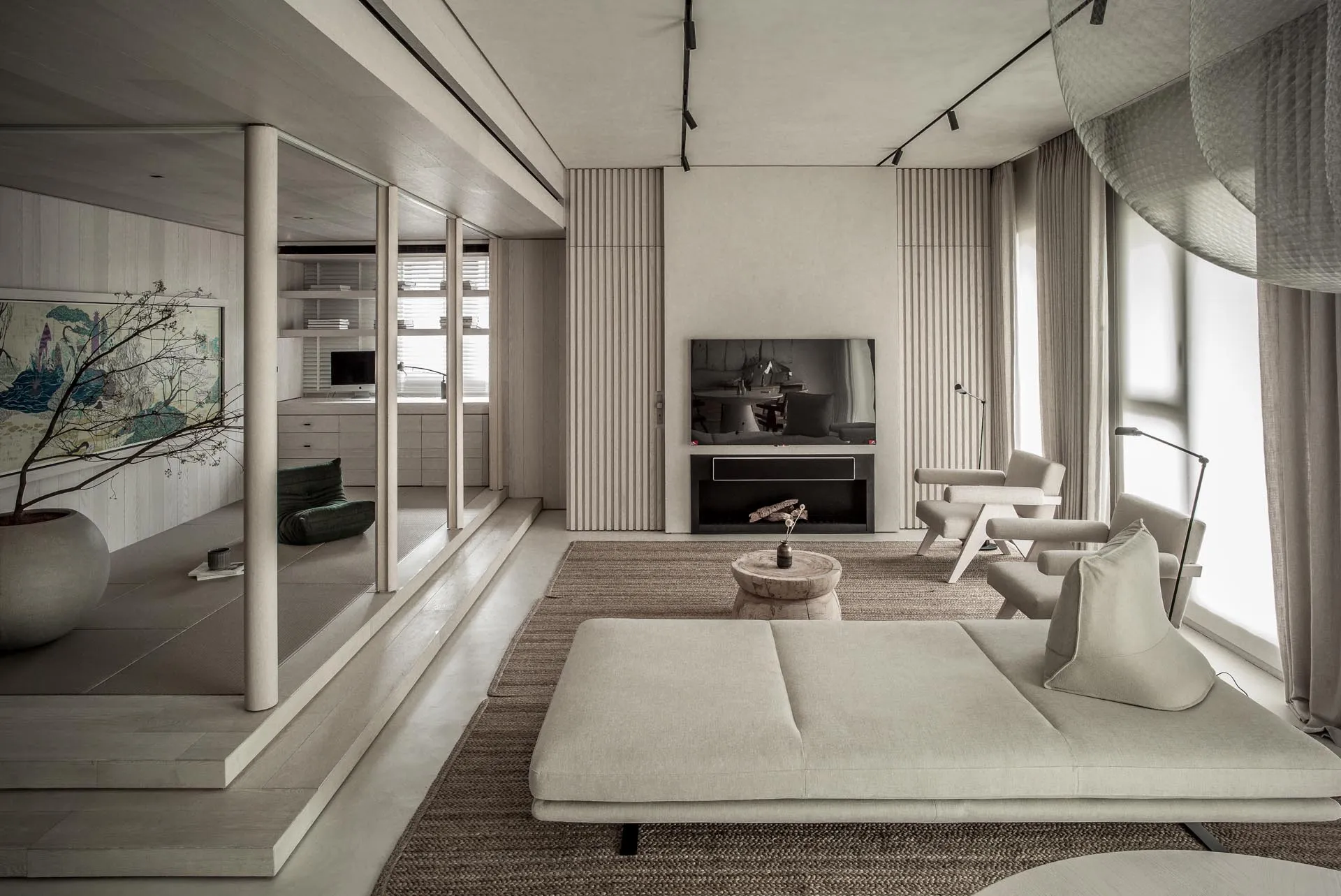 A modern minimalist living room with wood, concrete, and fabric materials and a low, comfortable sofa with a round wooden sid