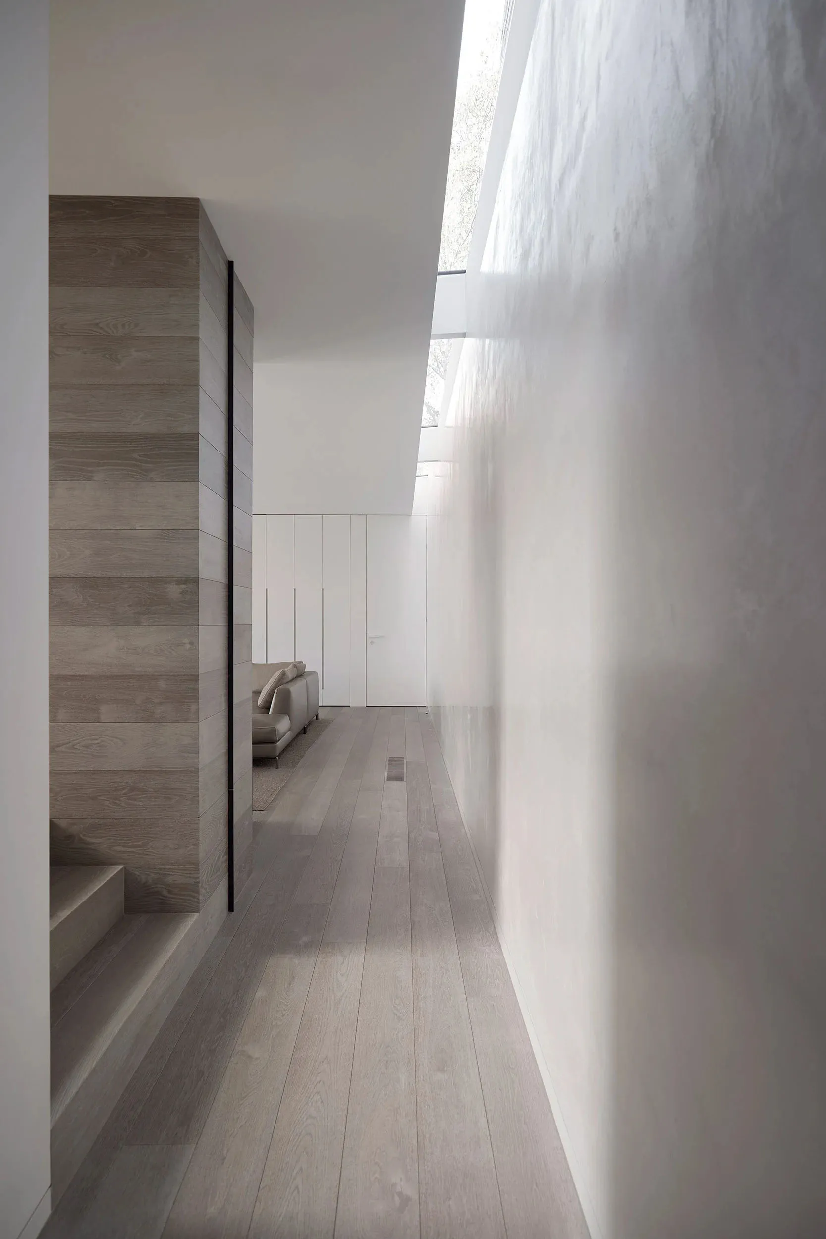 Modern minimalist residential interior design featuring wood flooring and minimalist architecture.