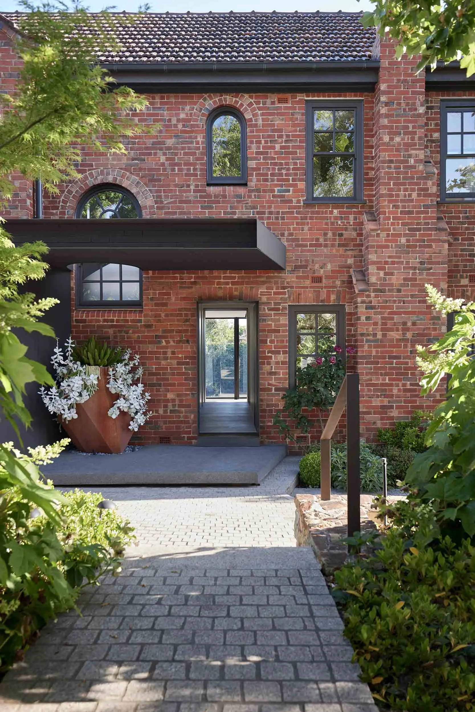 A modern residential entrance featuring brick walls and glass windows.