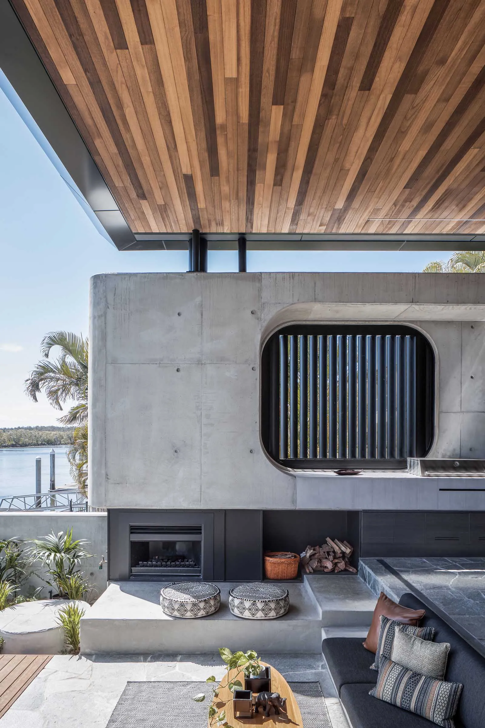 An industrial-style outdoor living area with a fireplace and barbecue grill.