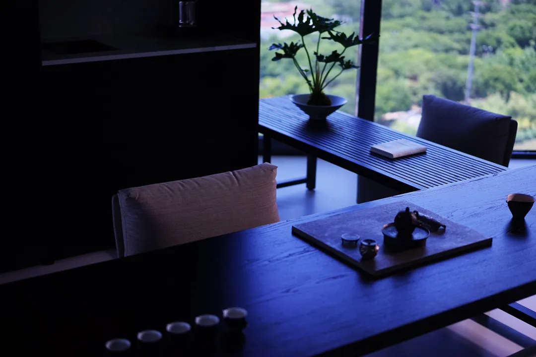 A minimalist office space featuring wooden furniture and a potted plant.