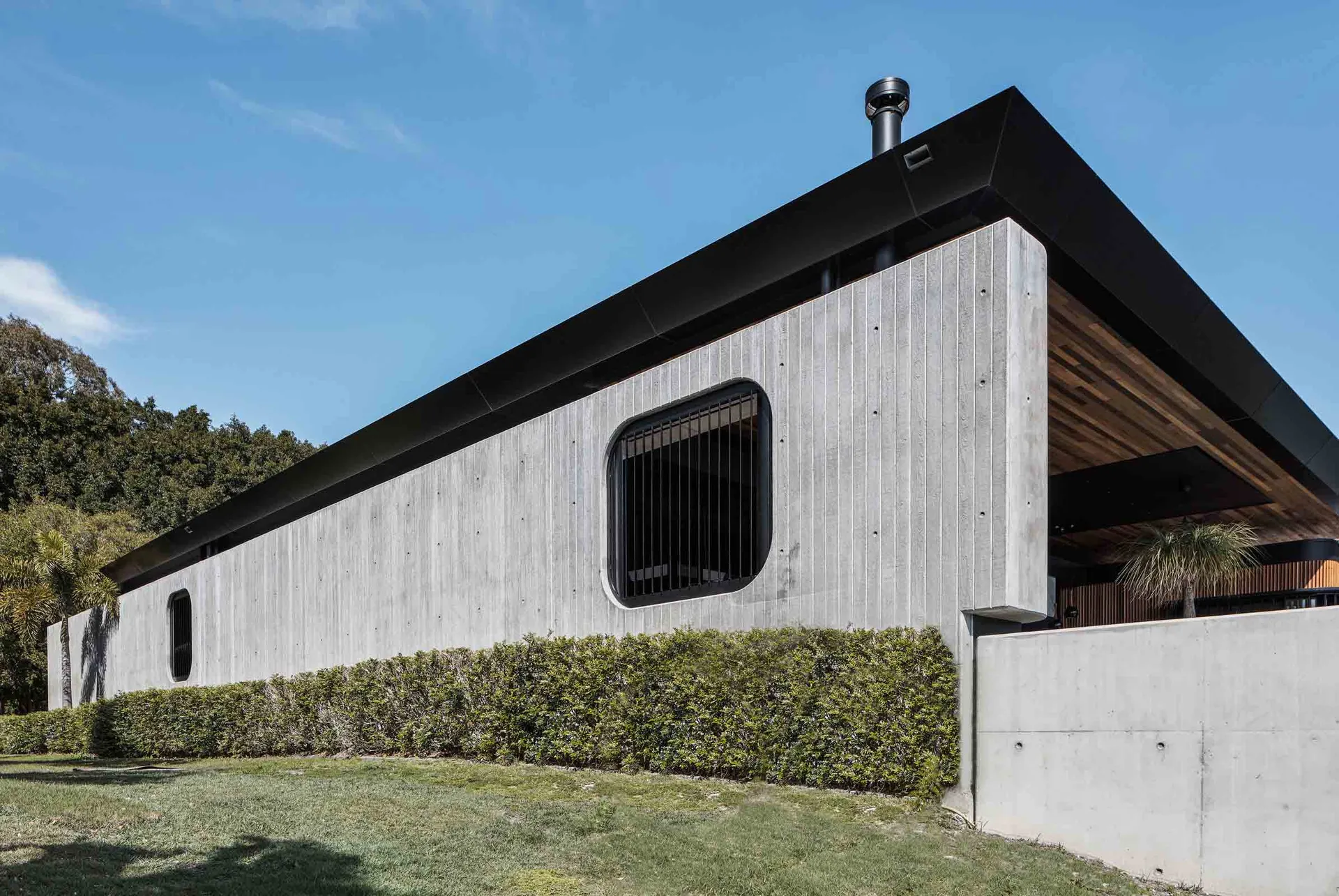 A modern architectural building with a concrete facade and black window frames.