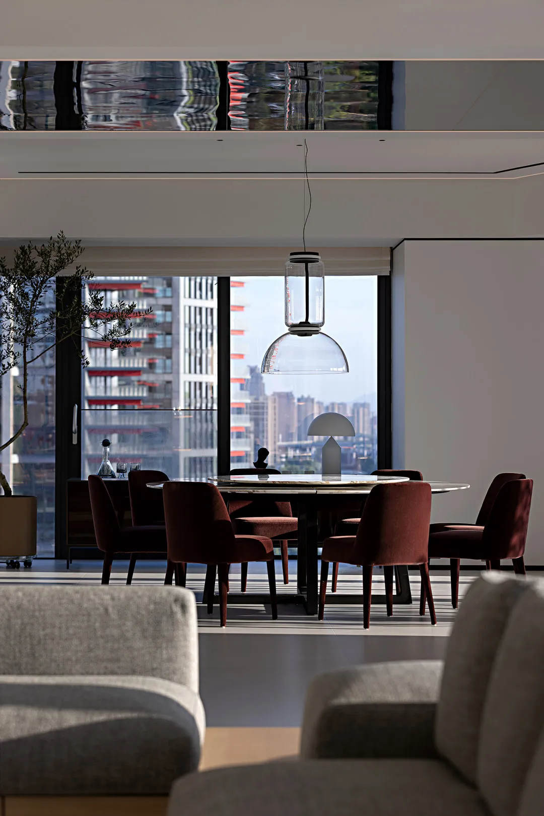 A modern living room with concrete and glass materials.
