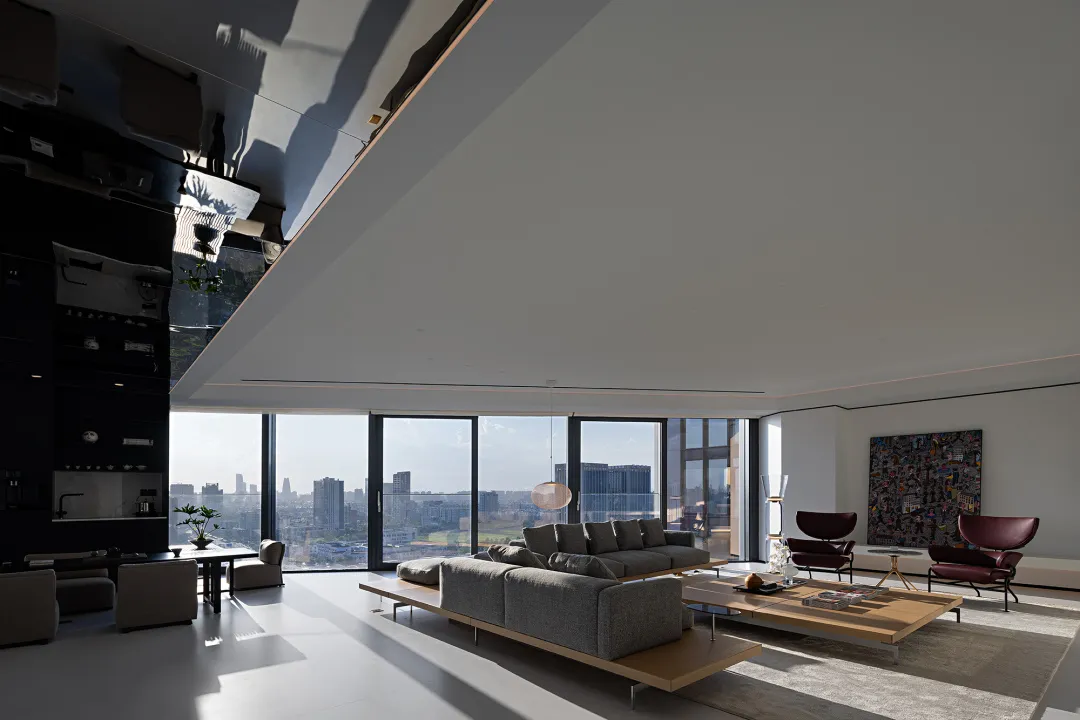 A modern living room with glass walls overlooking a cityscape.