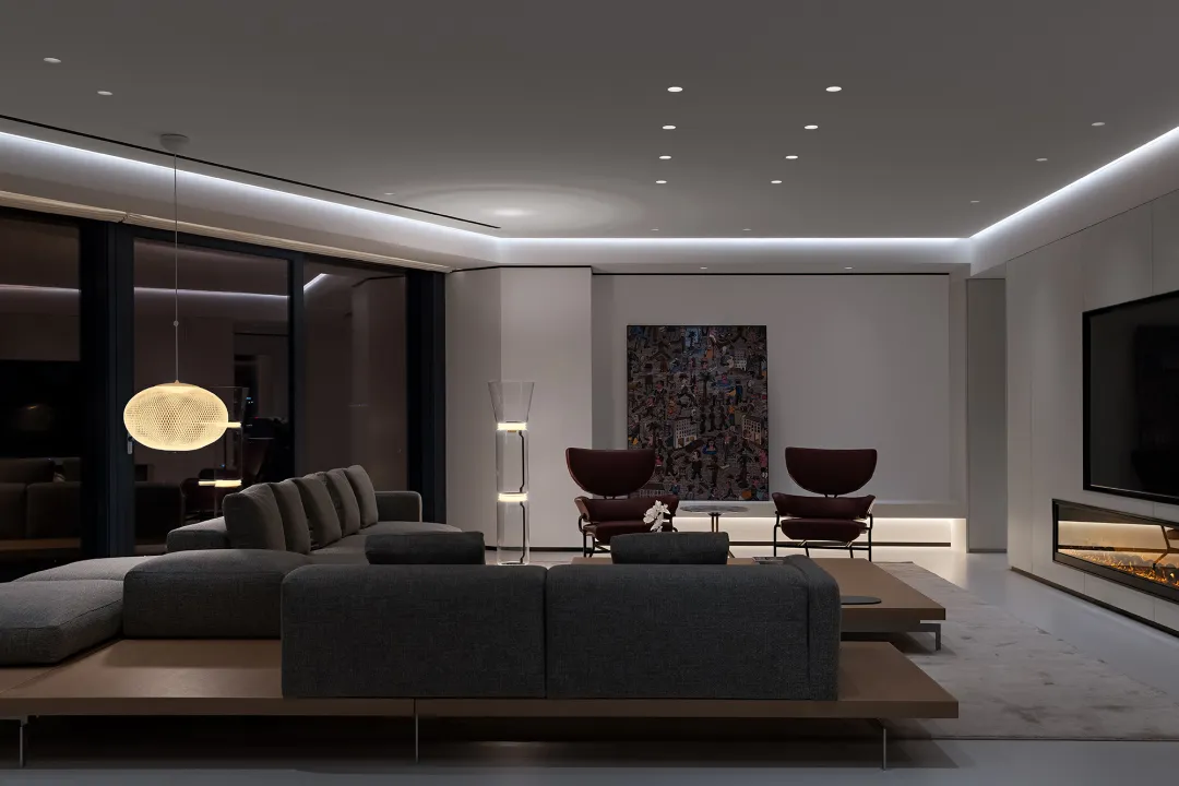 Modern living room featuring metallic accents, glass elements, and fabric seating.