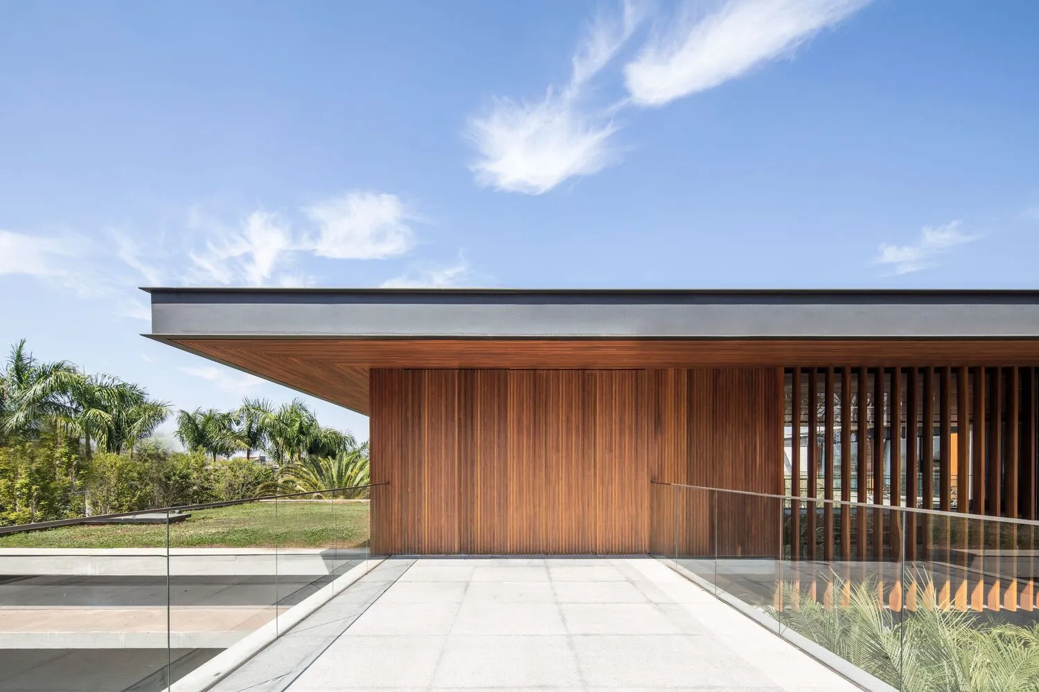 A modern minimalist exterior with wooden panels and a glass railing.