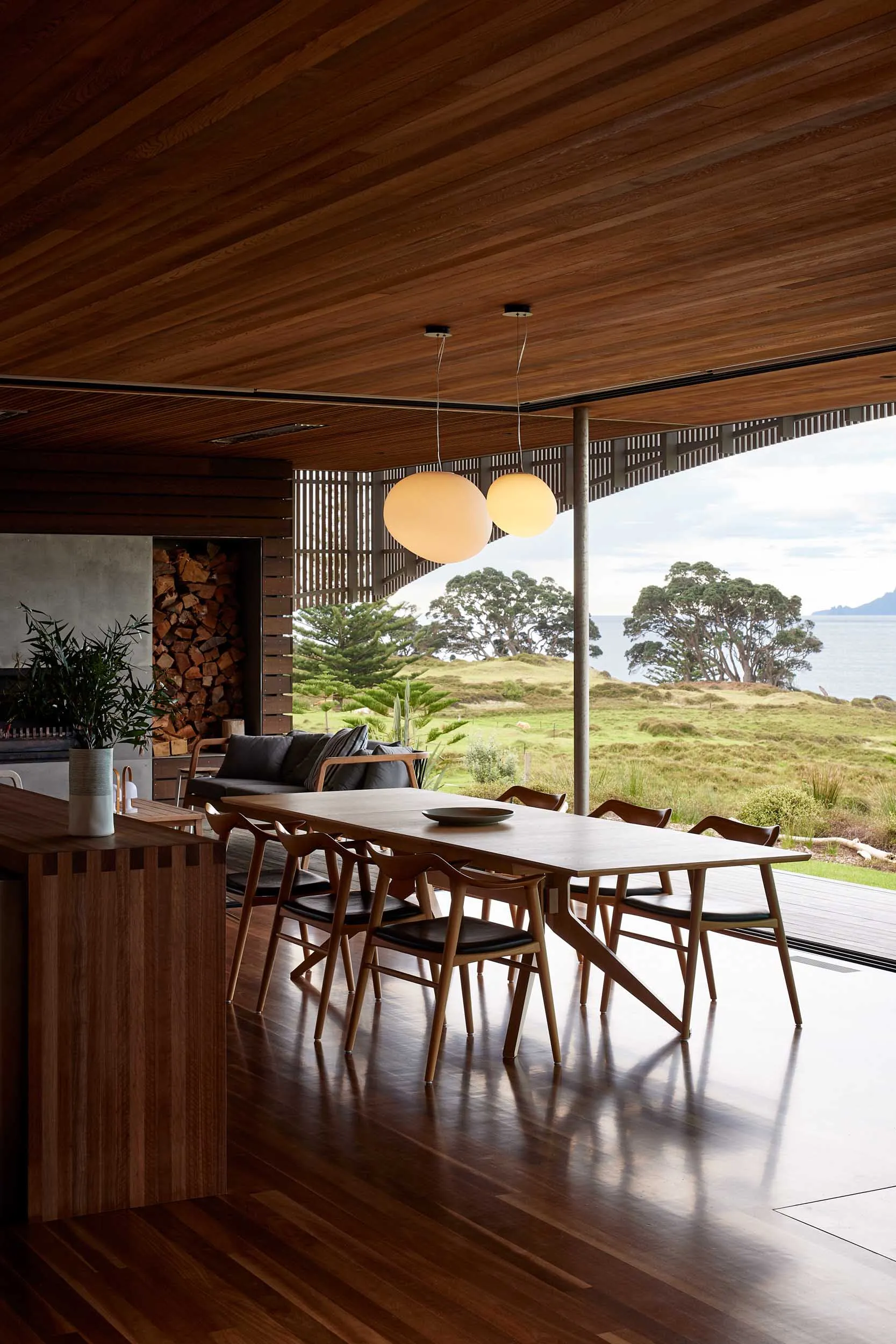 Living room with modern design, wooden flooring, and furniture, featuring a view of the countryside.