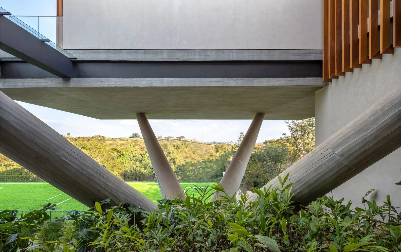 Modern exterior featuring concrete columns and a hillside background