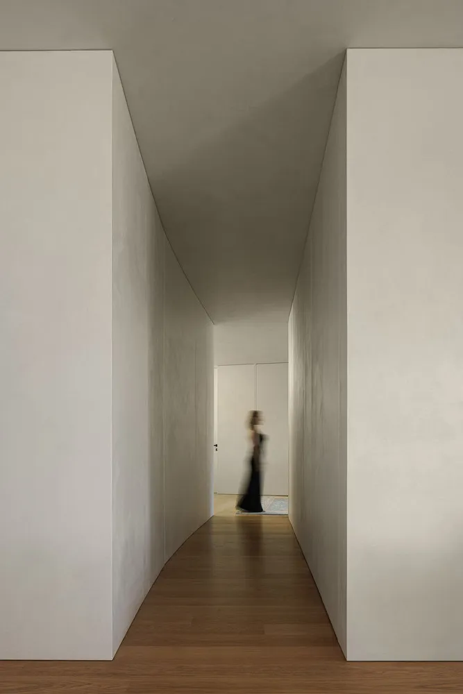 A minimalist hallway with concrete walls and wooden flooring