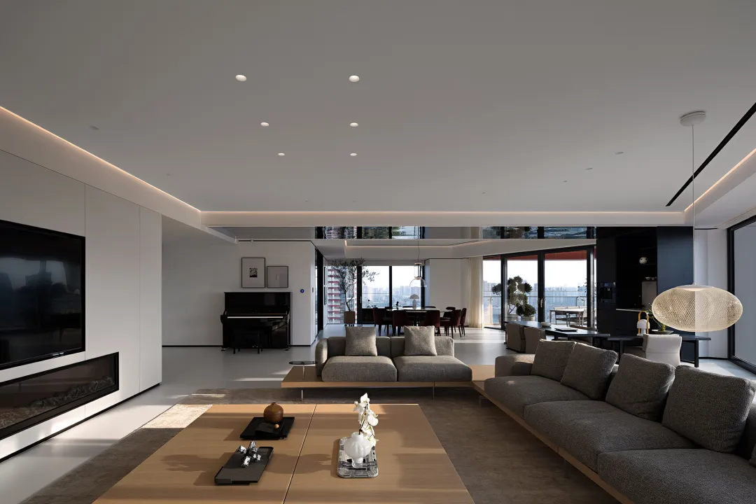 Modern residential living room featuring concrete, glass, leather, and wood finishes.