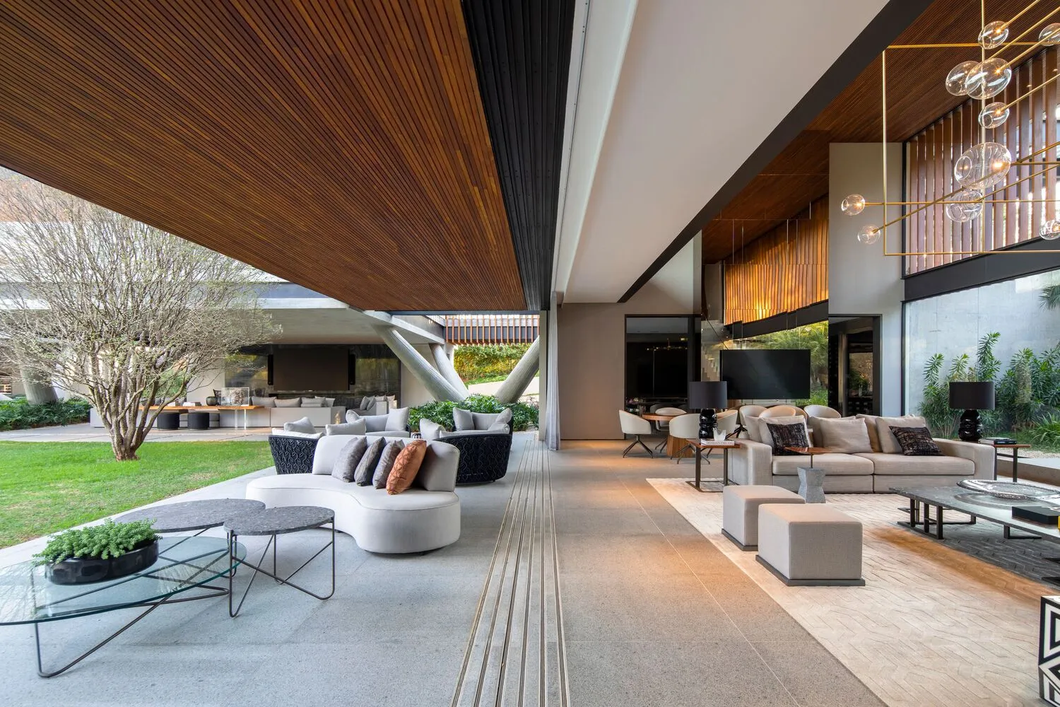 A modern living room with concrete, glass, and wooden elements.