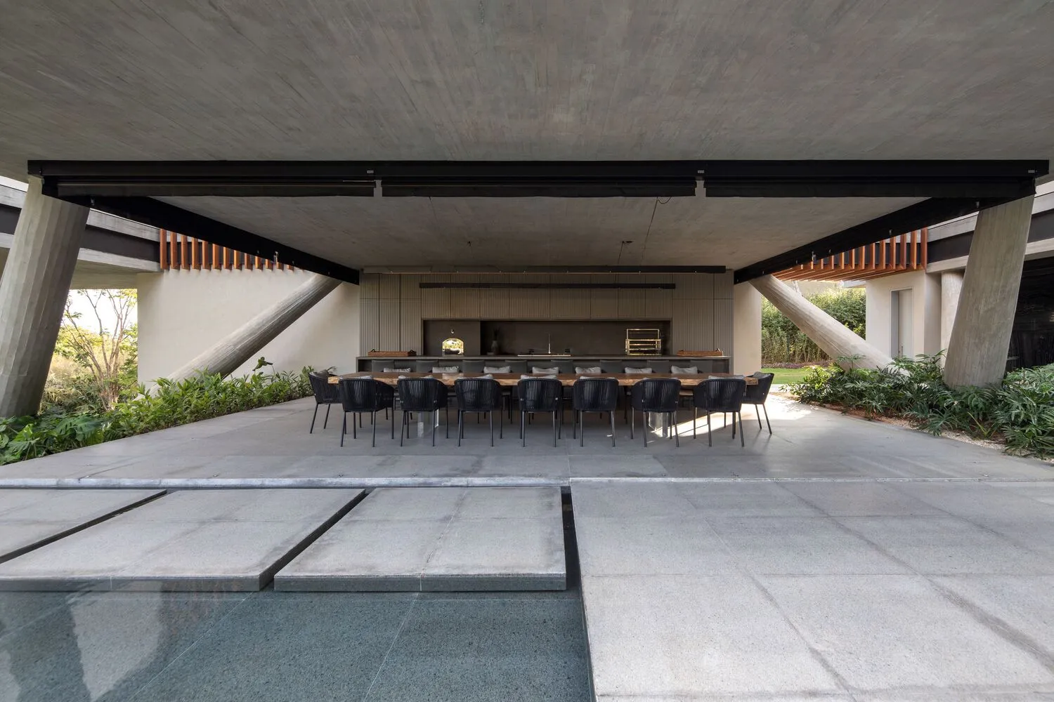 A modern patio featuring concrete furniture and a sleek design.