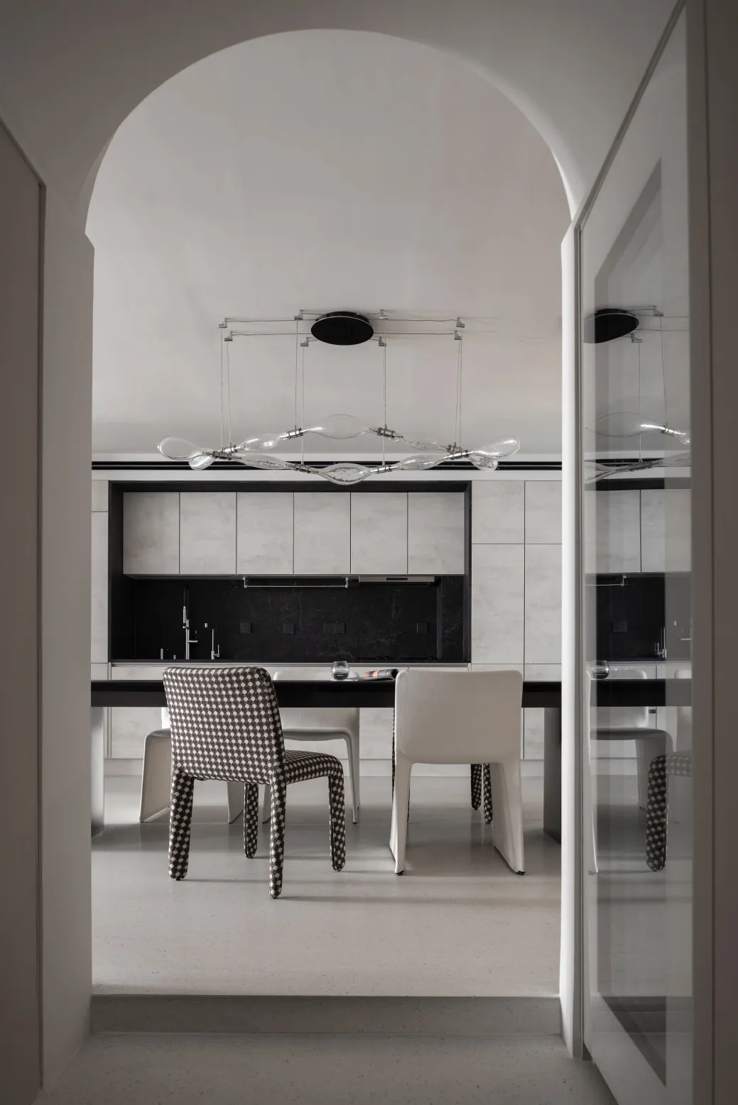 A contemporary kitchen featuring minimalist design with concrete and glass materials.