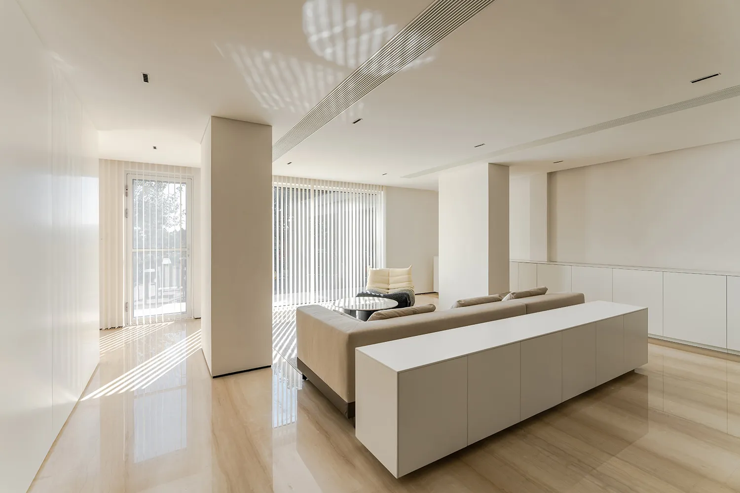 A modern minimalist living room featuring concrete walls and floor.