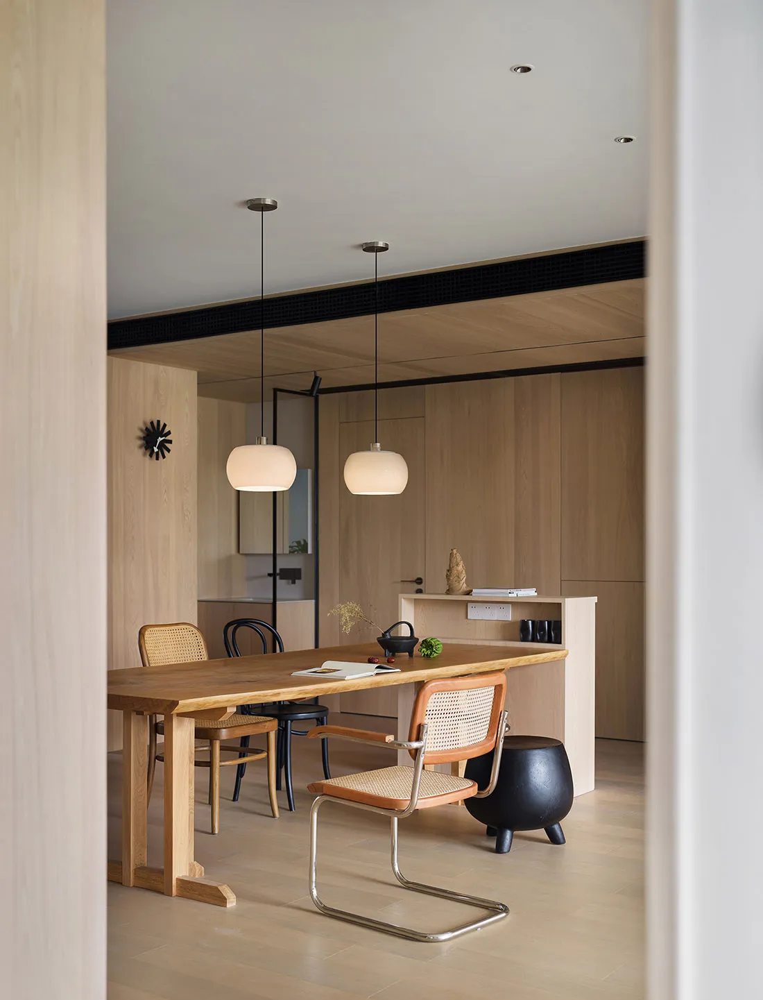 Modern dining area featuring a wooden table and chairs in a contemporary interior design setting.