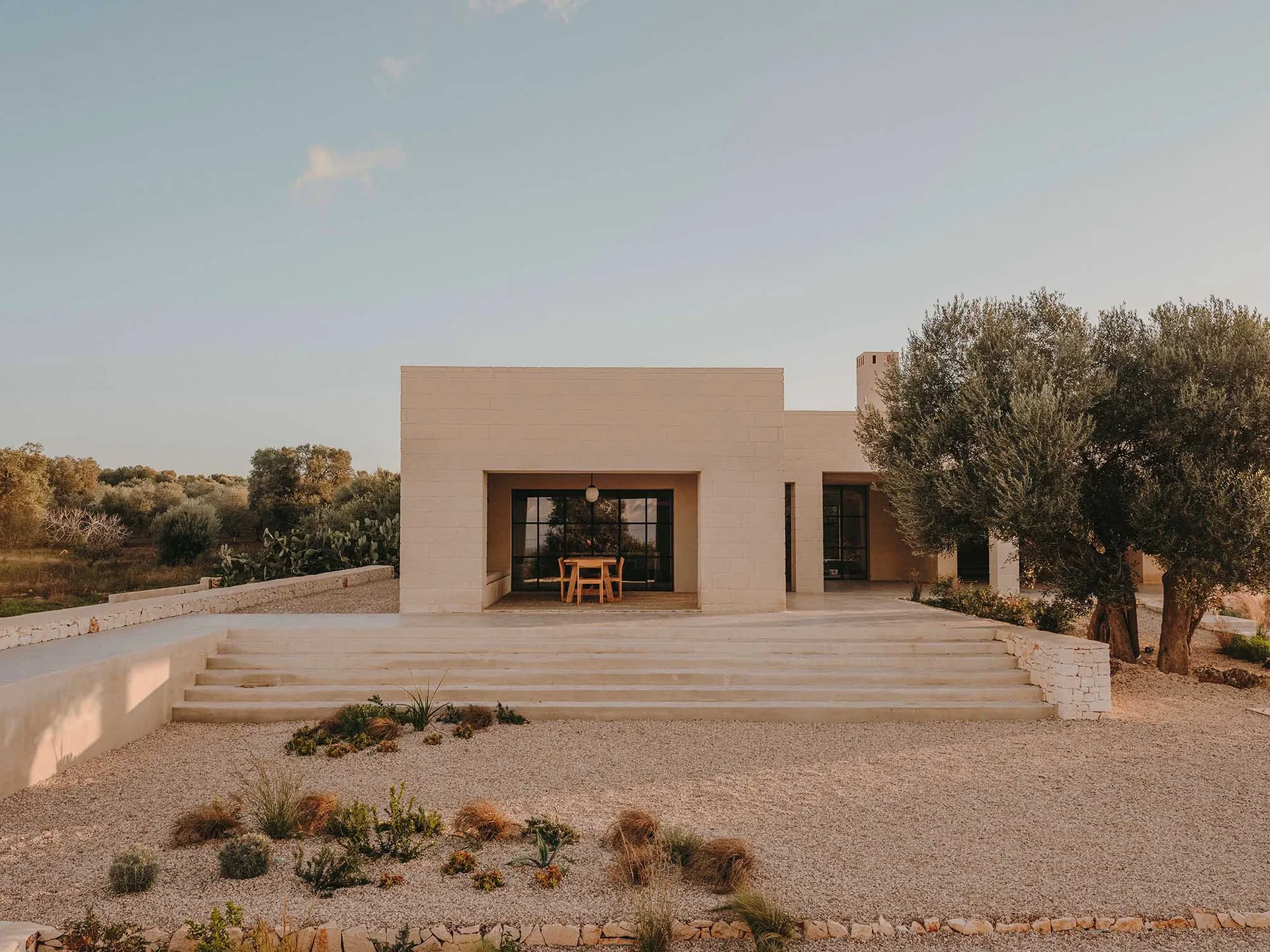 A minimalist residential exterior with concrete walls and large windows.