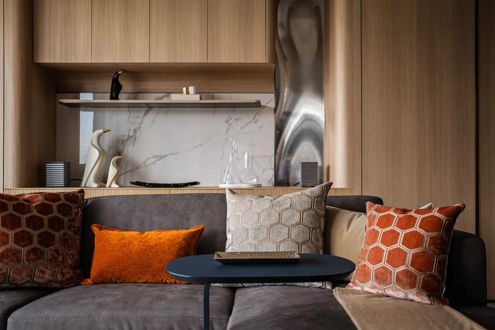 Modern living room with leather sofa, marble accents, and wooden elements.