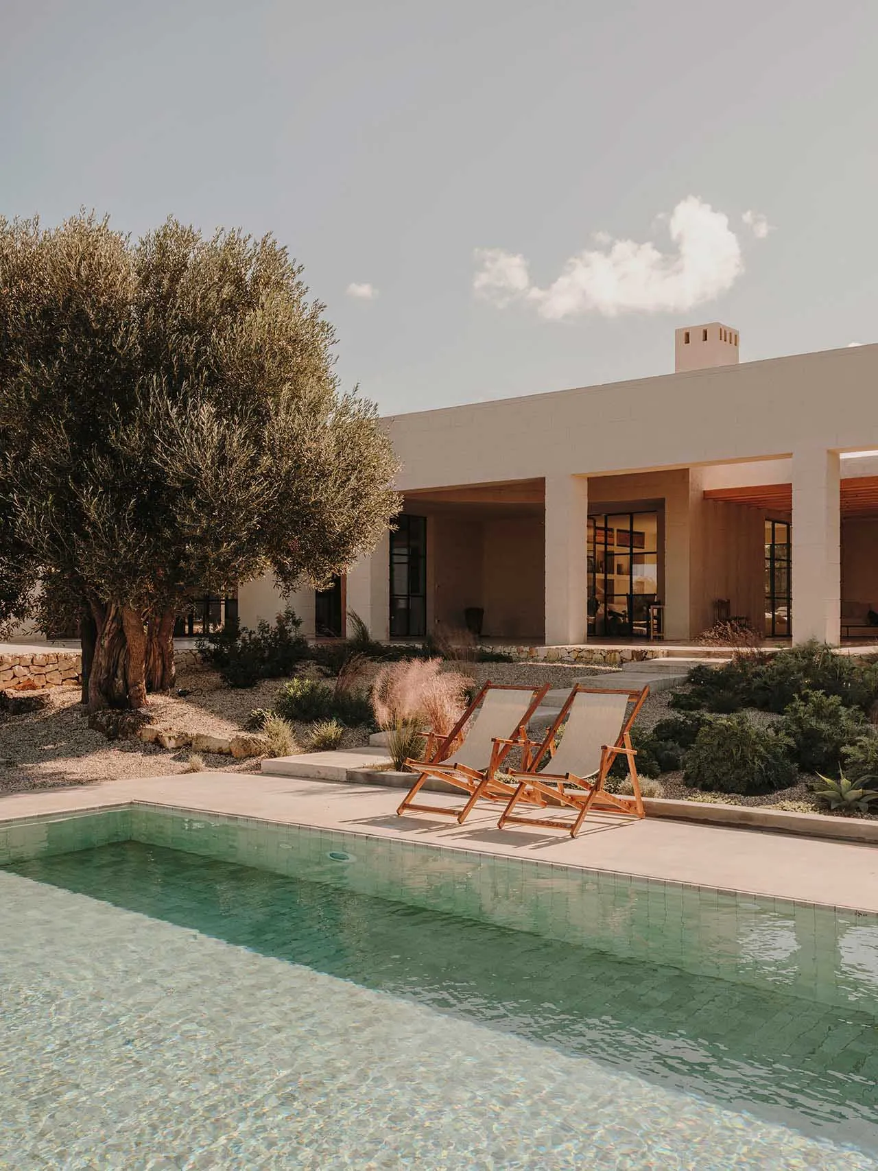 Modern minimalist residential exterior featuring concrete and glass elements.