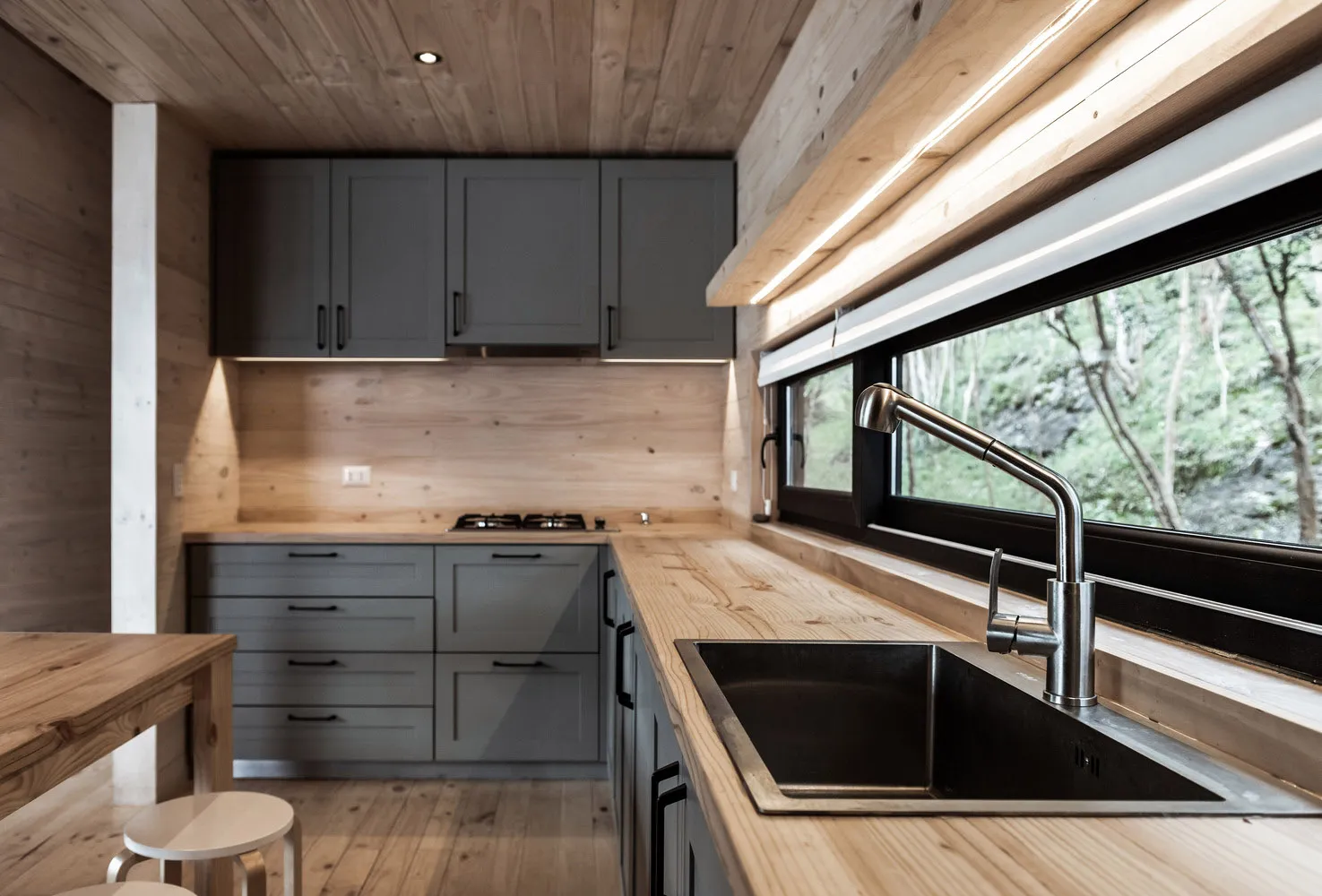 A modern kitchen with wooden countertops and metal sink.