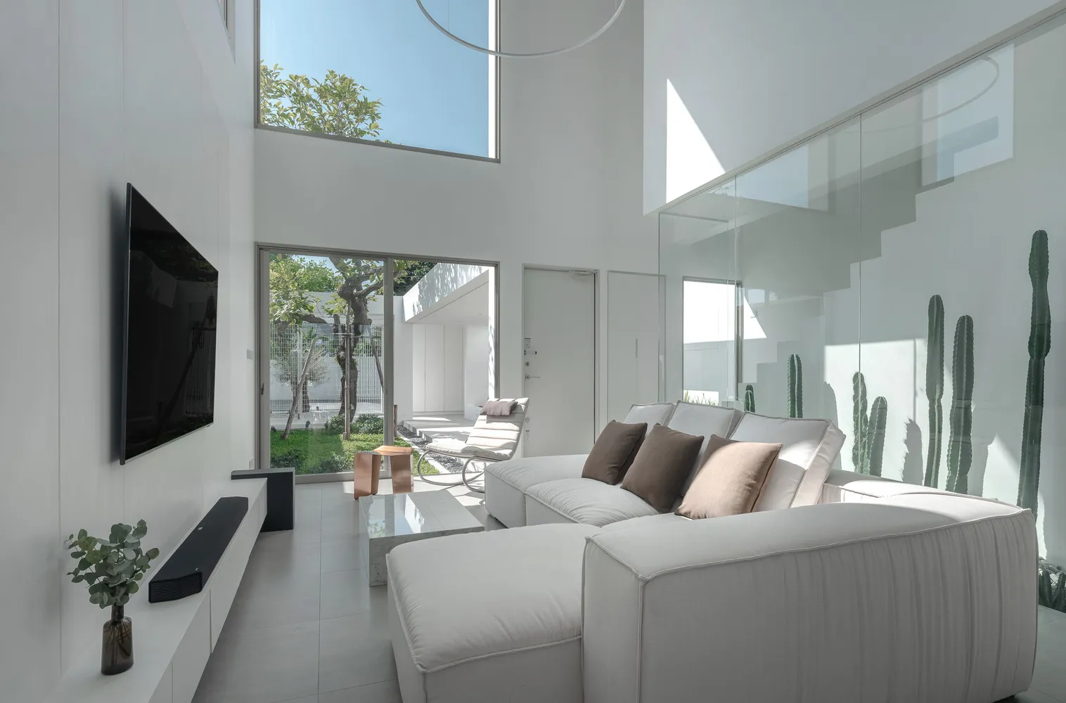 Modern living room featuring glass walls, concrete flooring, and minimalist furniture.