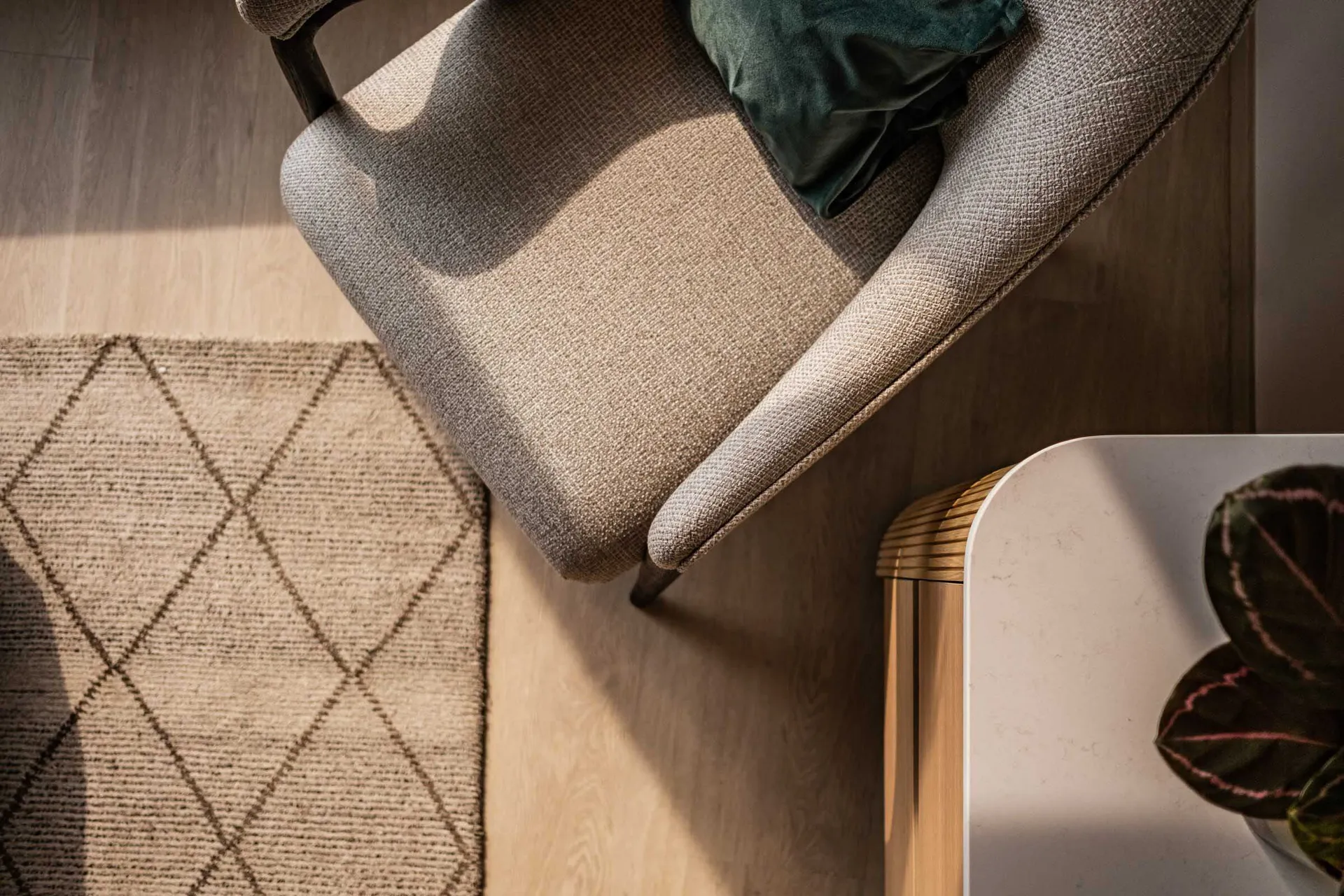 A modern minimalist living room featuring a patterned fabric chair with dark wooden legs, a green cushion, and a woven diamon