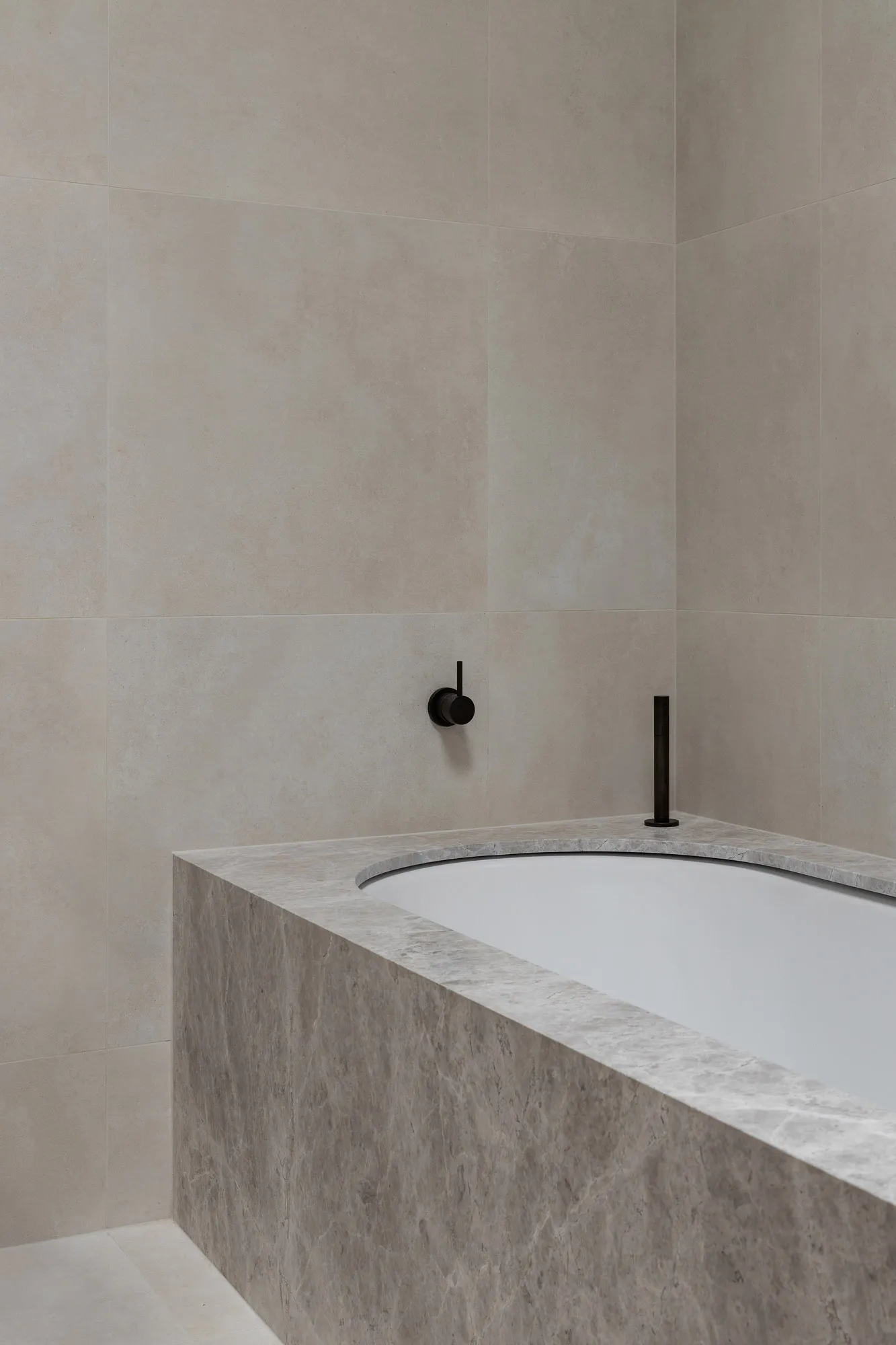 Modern minimalist bathroom featuring marble elements and a freestanding bathtub