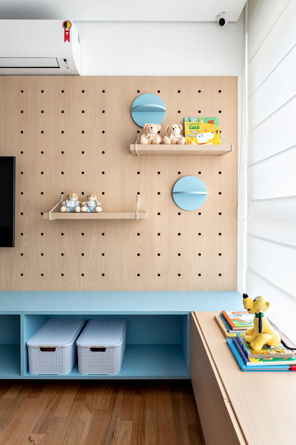 Play area with a pegboard wall featuring storage shelves and toy organization, suitable for children's room design.