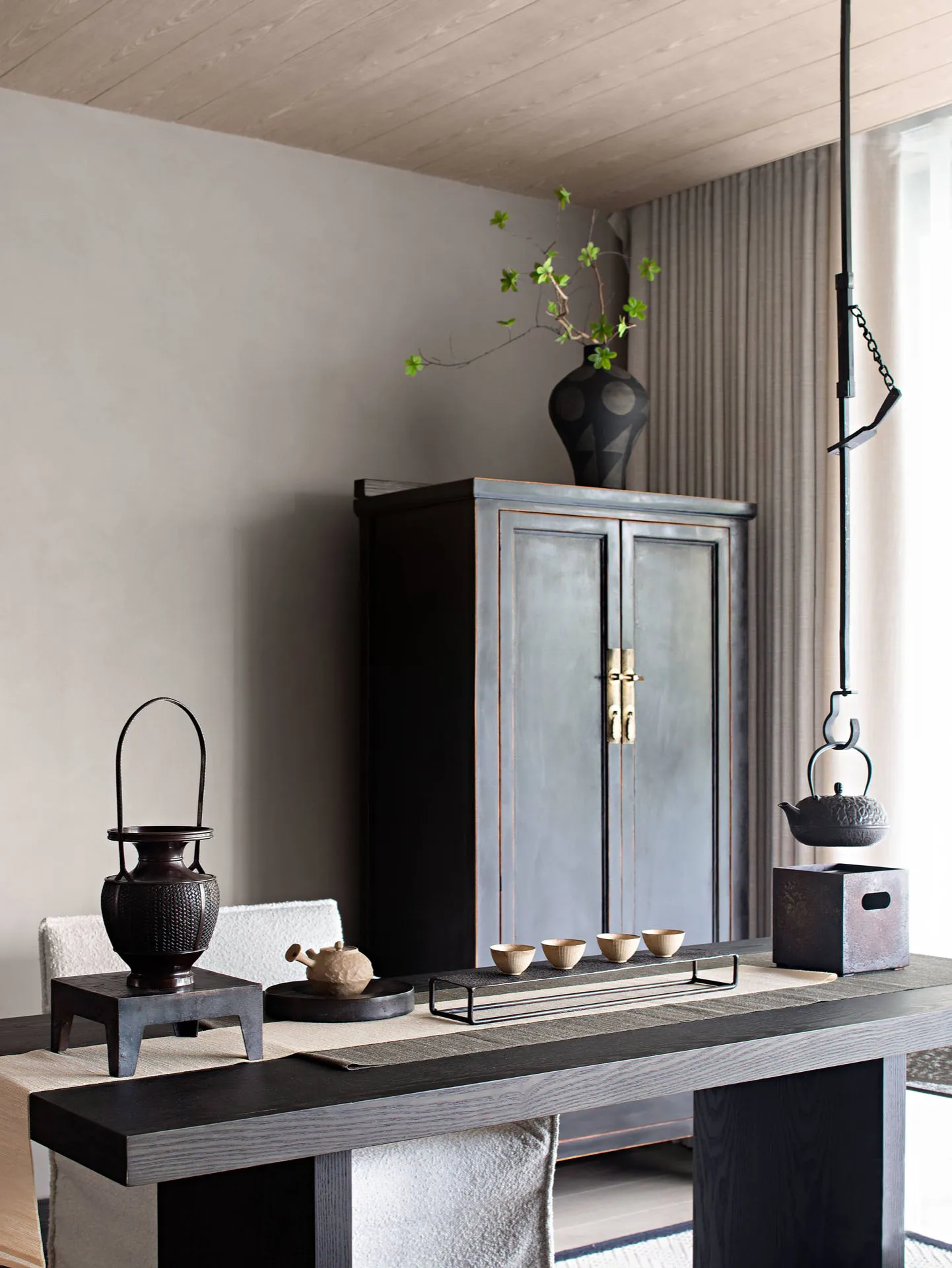 A minimalist tea house interior with wooden furniture, tea cups, and decorative elements.