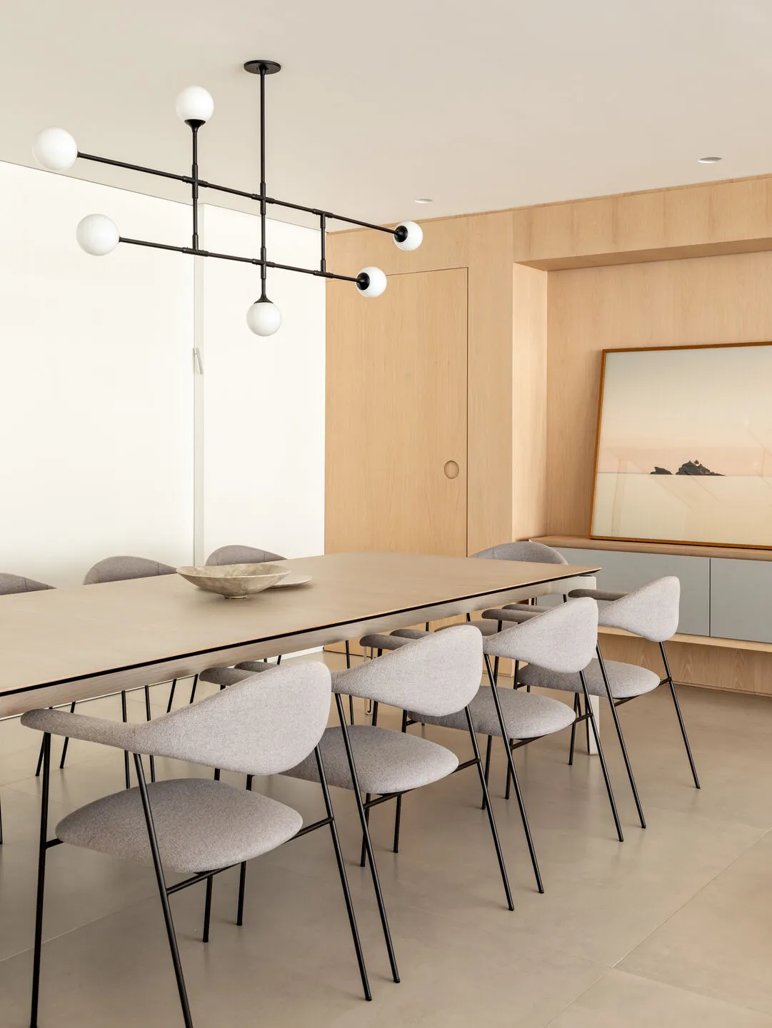 A modern dining room featuring wooden furniture and a minimalist design.