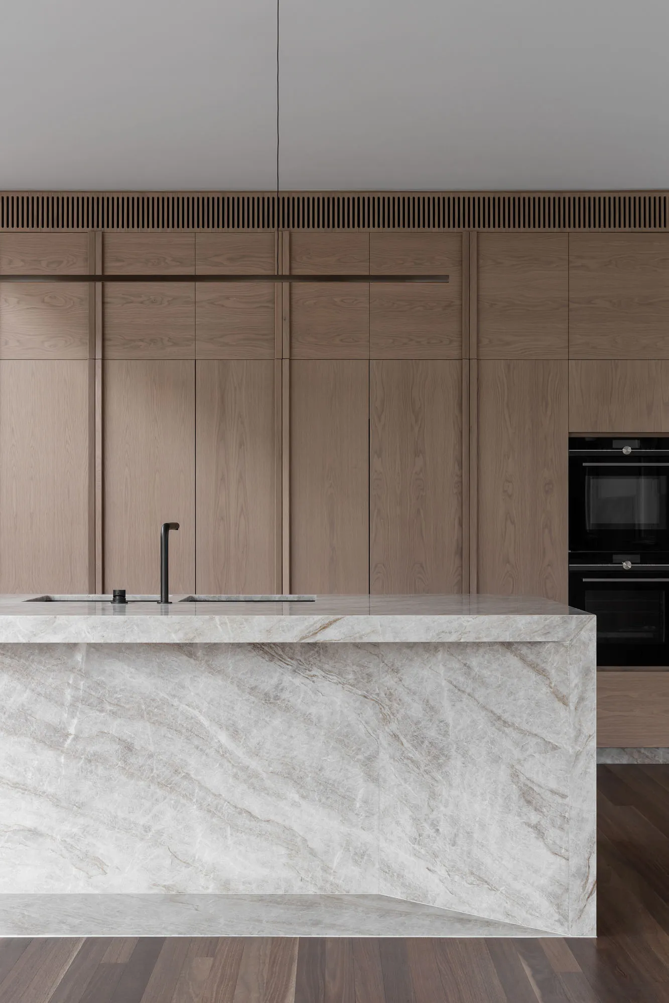 Modern kitchen with marble countertops and wooden cabinets