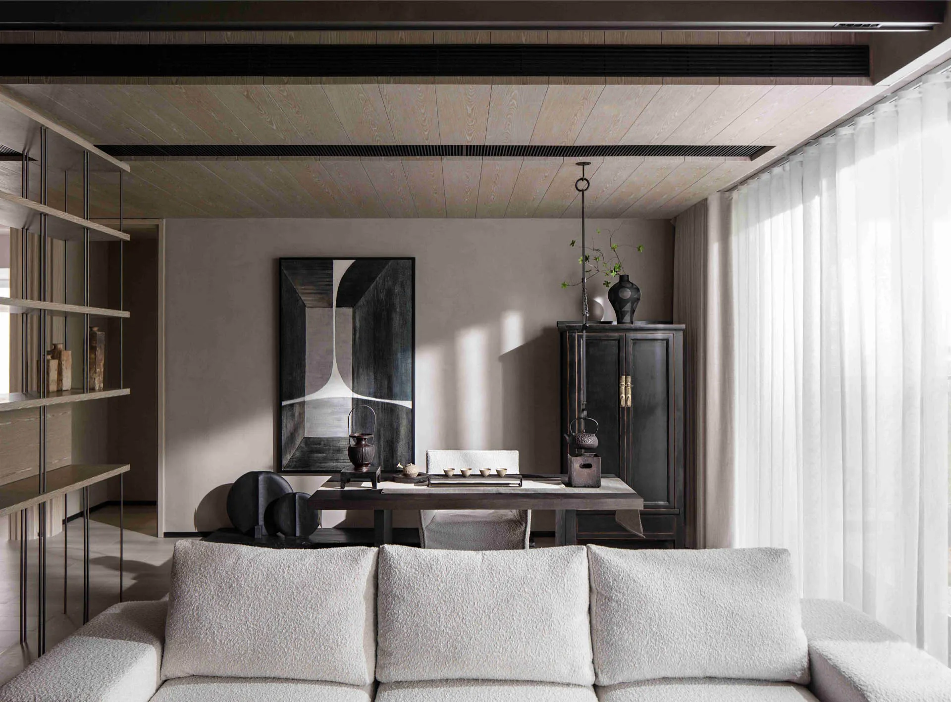 A modern living room featuring a white sofa, a wooden dining table, and a large abstract painting on the wall.