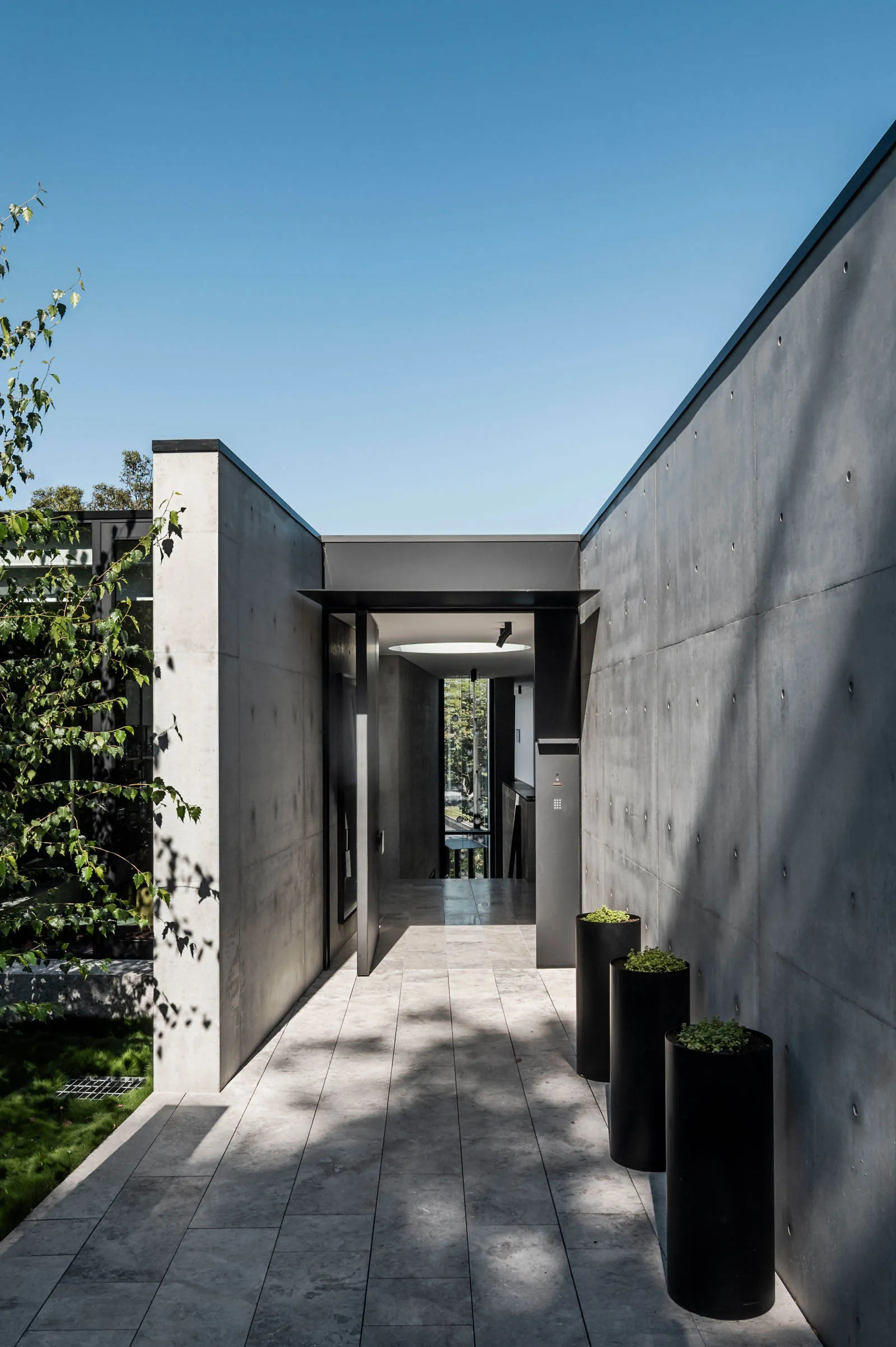 Modern entrance with concrete walls and black metal accents.