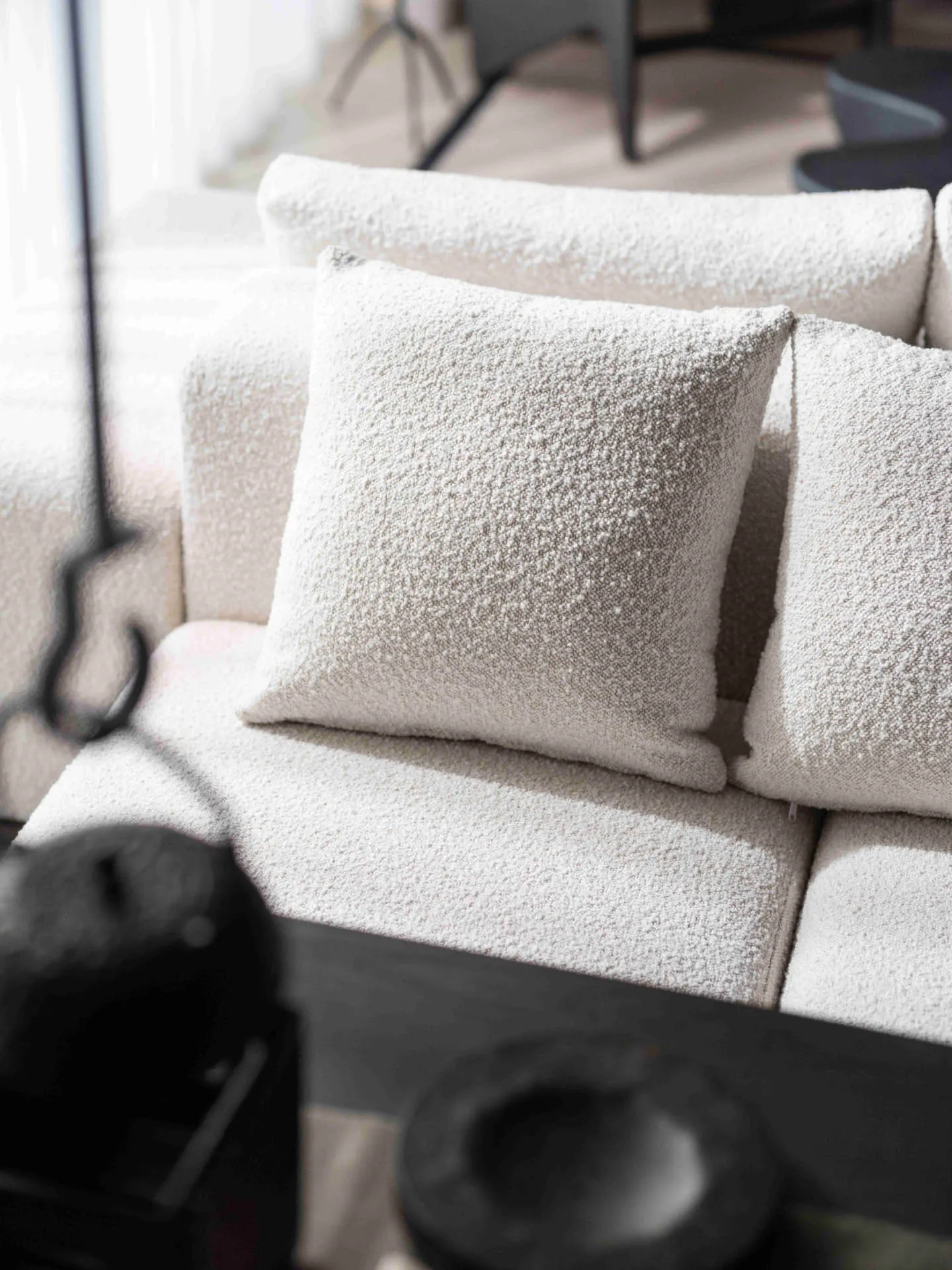 A modern home decor scene showcasing a textured fabric couch with square pillows.