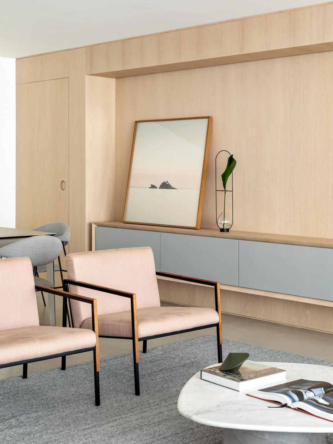 A modern living room featuring minimalist design, wood furniture, and gray elements.