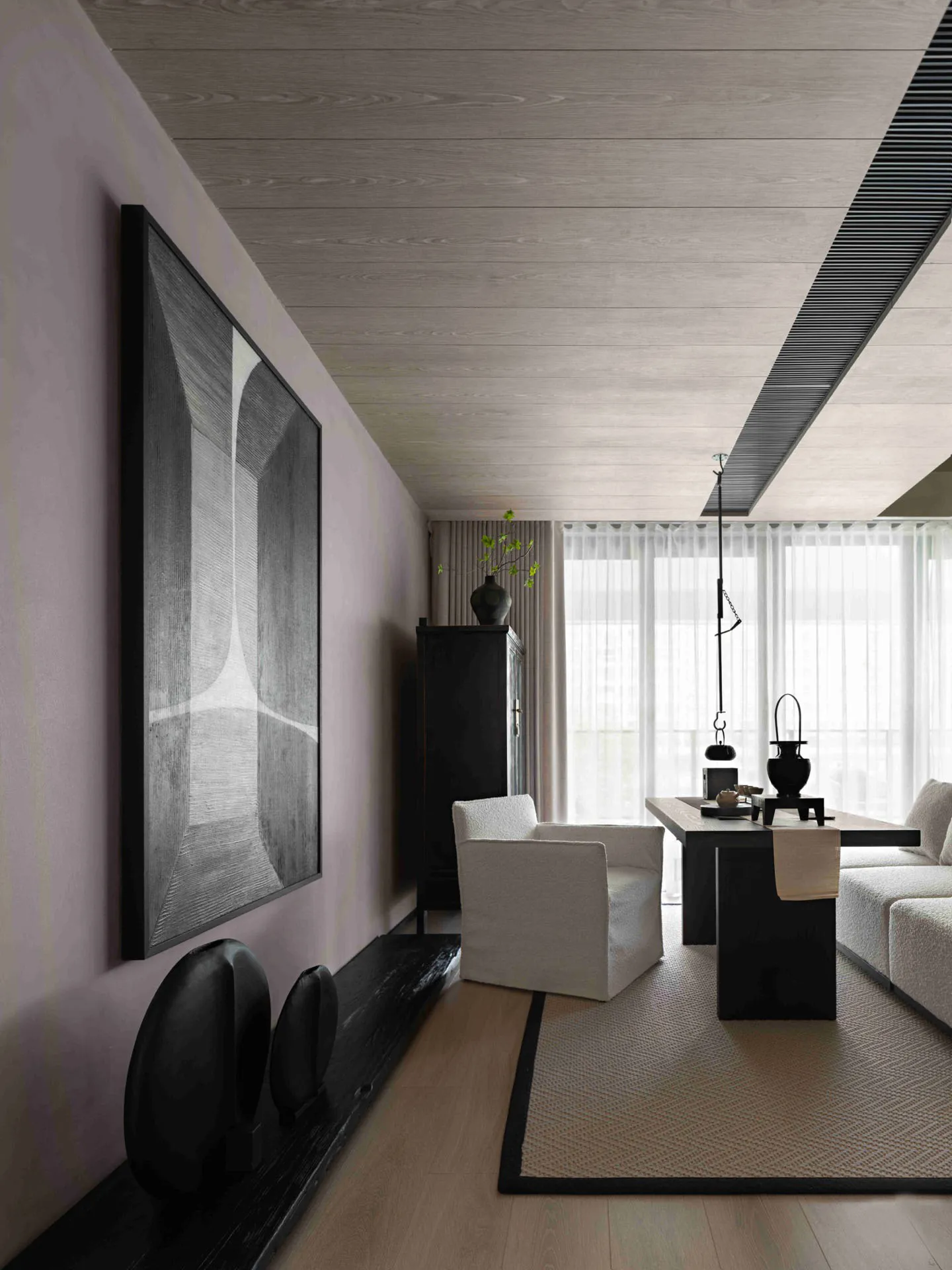 Modern living room featuring wooden flooring, white furniture, and black accents with a large abstract art piece on the wall.