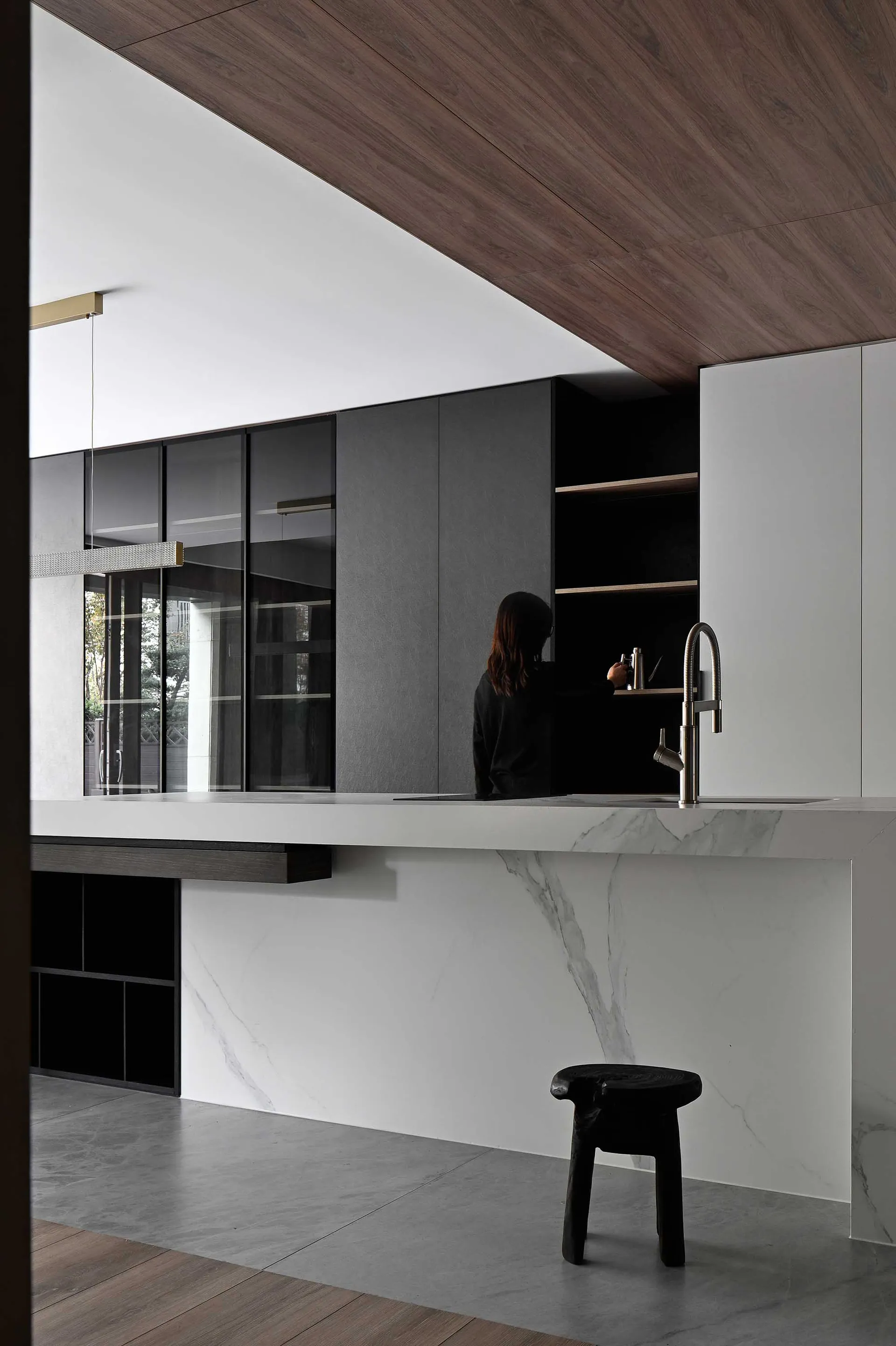 A modern kitchen featuring a white marble countertop and a sleek black faucet.