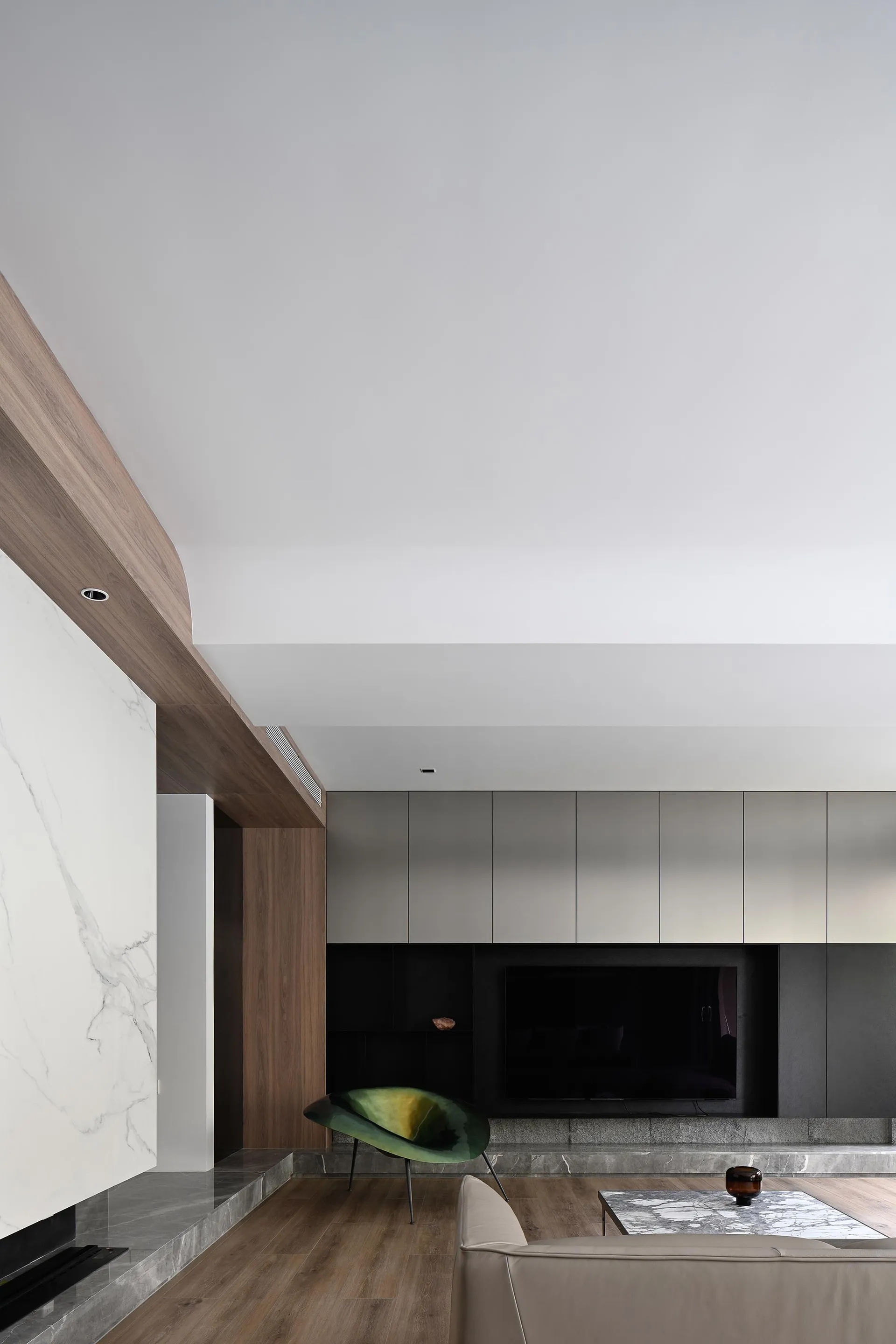 A modern living room featuring marble and wooden elements.