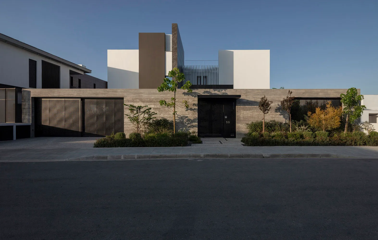 A modern residential exterior featuring concrete and metal materials.