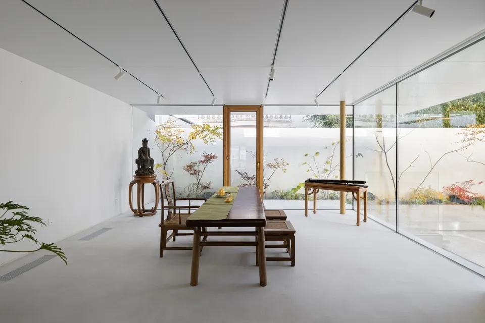 A minimalist interior design featuring a white concrete floor and wooden furniture.