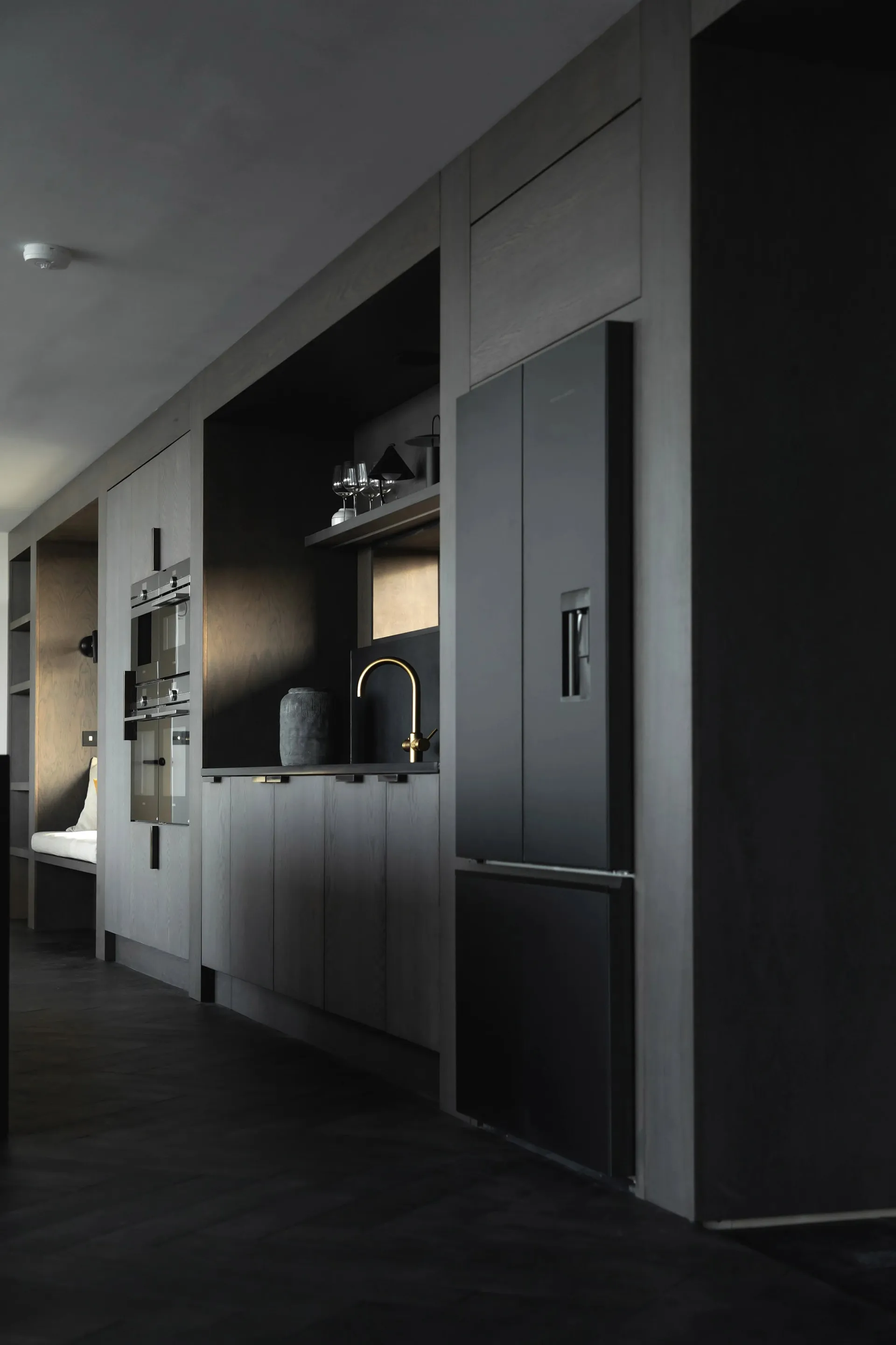 Modern kitchen featuring grey wooden cabinets, metallic accents, and a minimalist design.