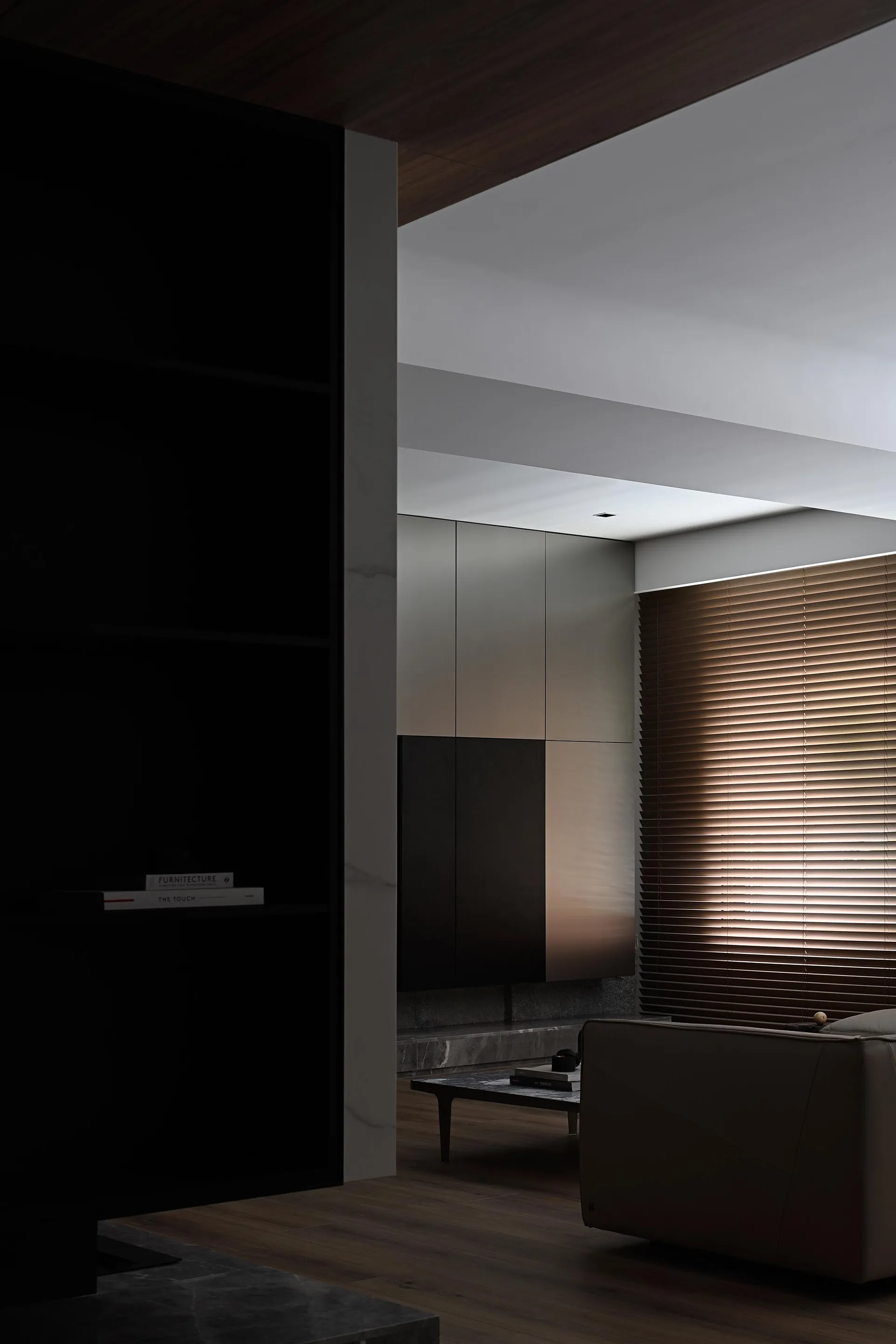 Modern minimalist living room featuring wooden ceiling panels and sleek, contemporary furniture.