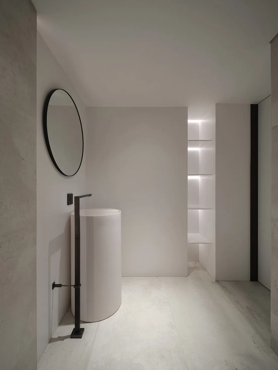 A minimalist bathroom with a modern concrete sink and white walls.