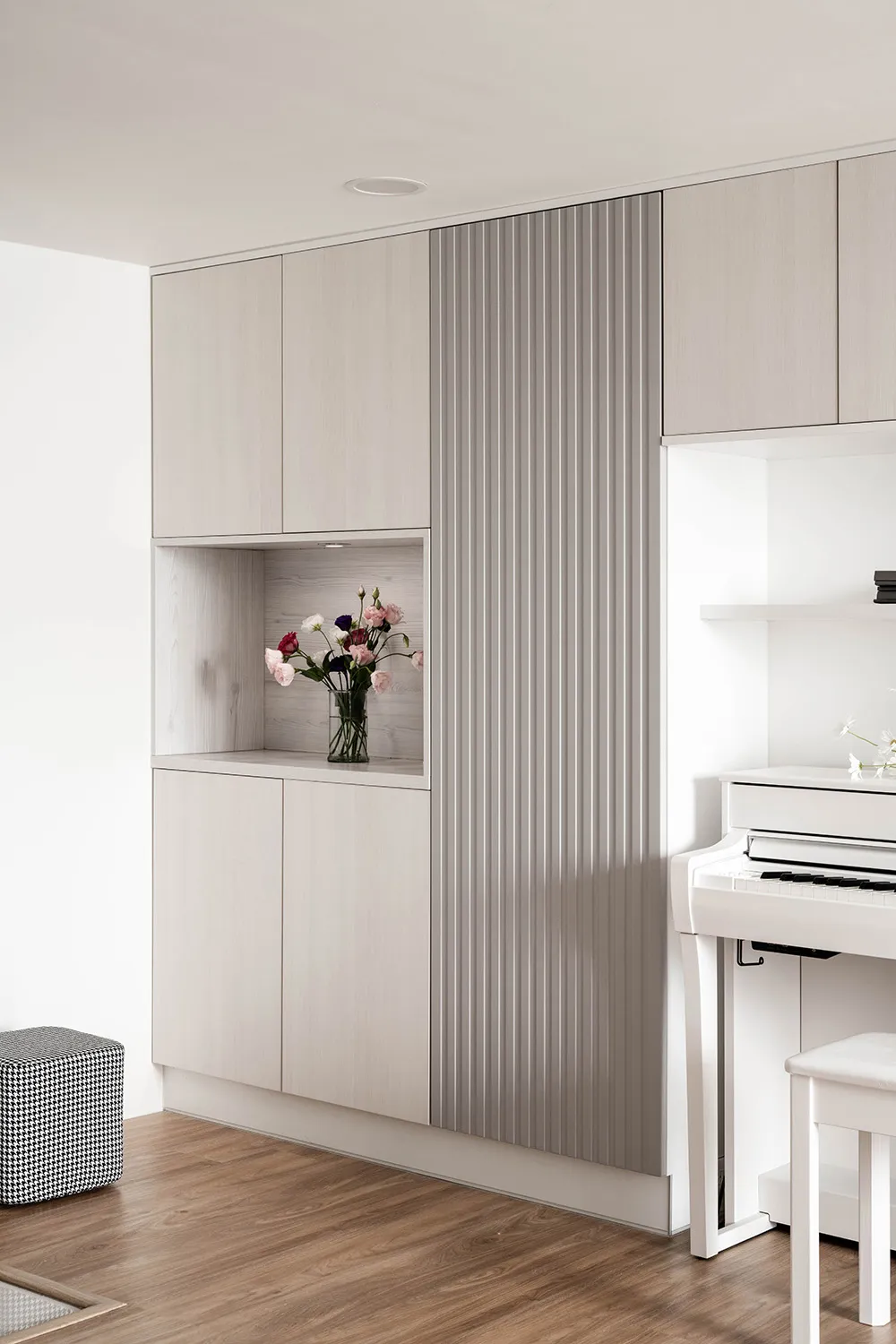 Modern minimalist living room with wooden cabinets and a white piano.