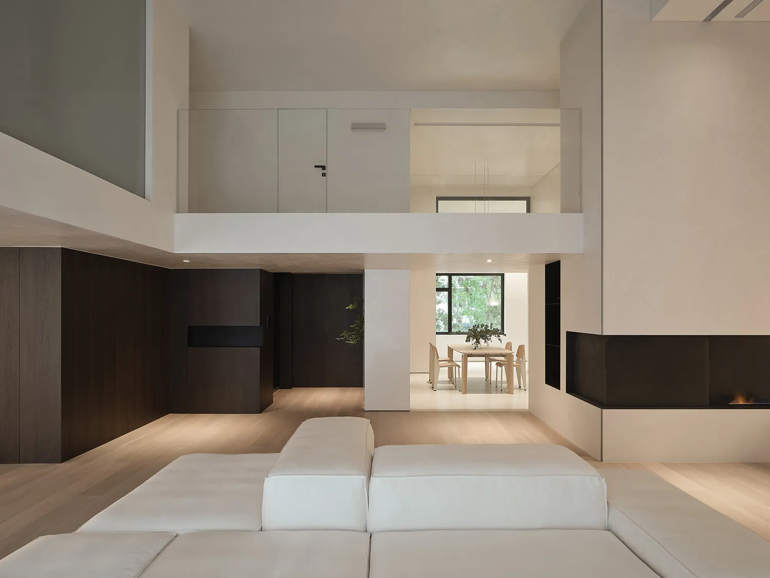 Modern minimalist living room with wooden furniture, concrete accents, and textiles on the floor.