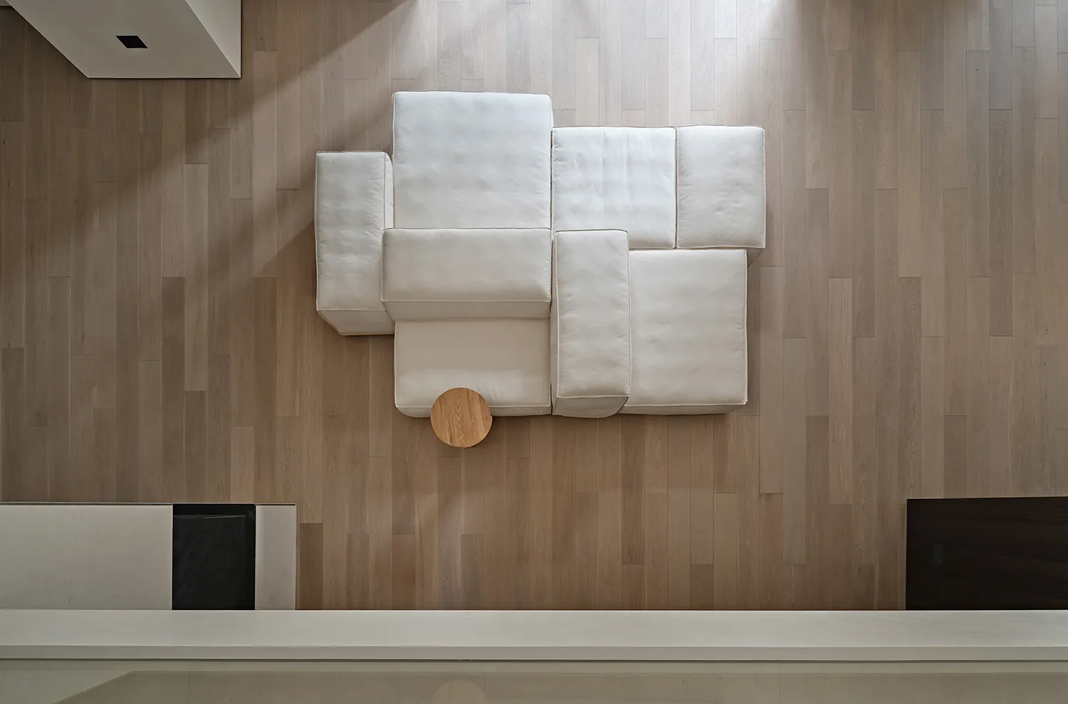 Modern minimalist sofa upholstered in white fabric, featuring a contemporary design.